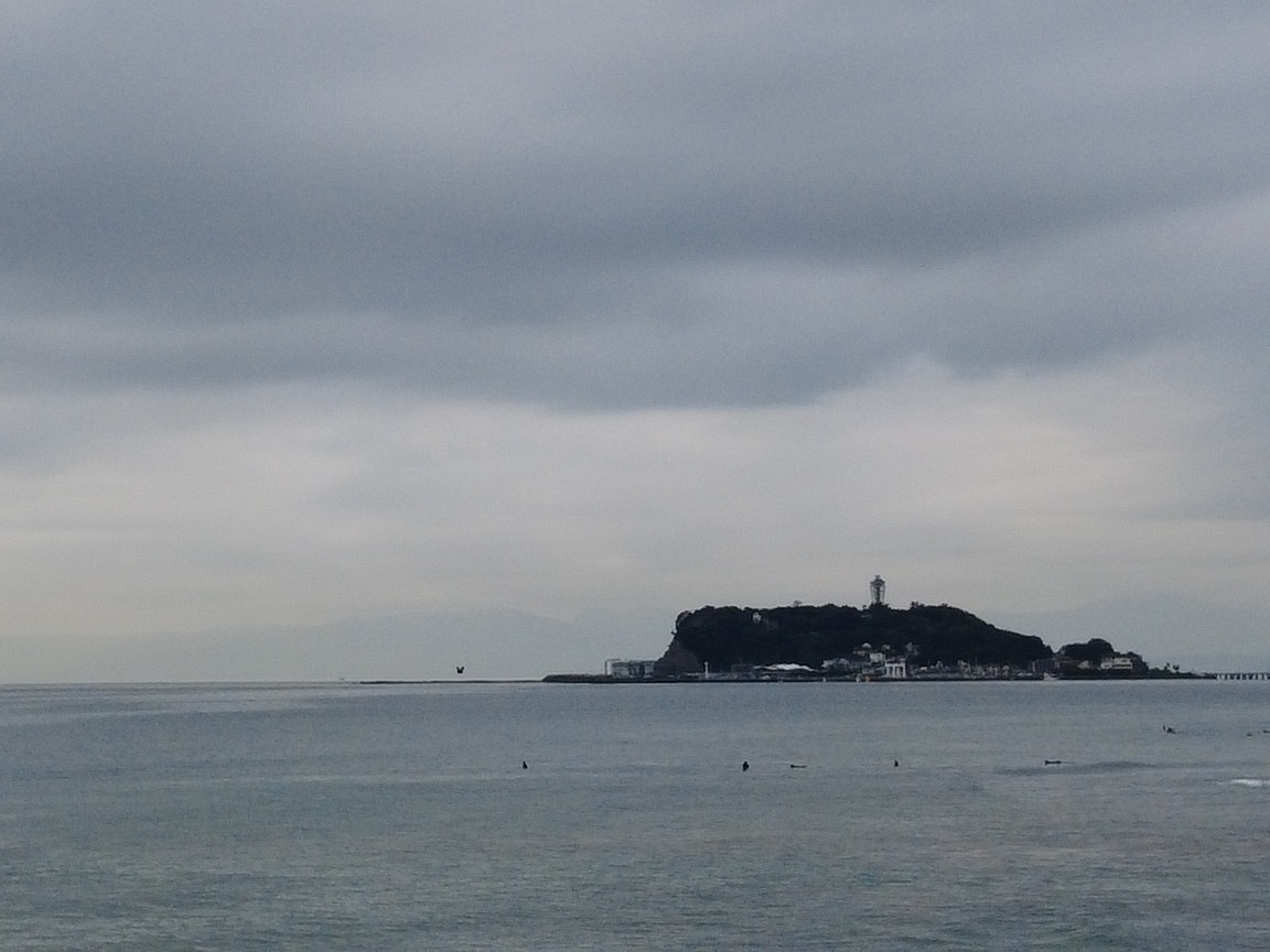 海辺から望む小島と灯台のある景色