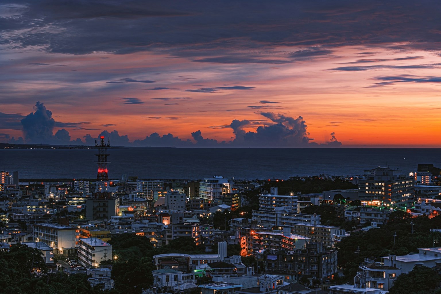 Panoramablick auf die Stadt mit wunderschönem Sonnenuntergangshimmel und Ozeanhorizont