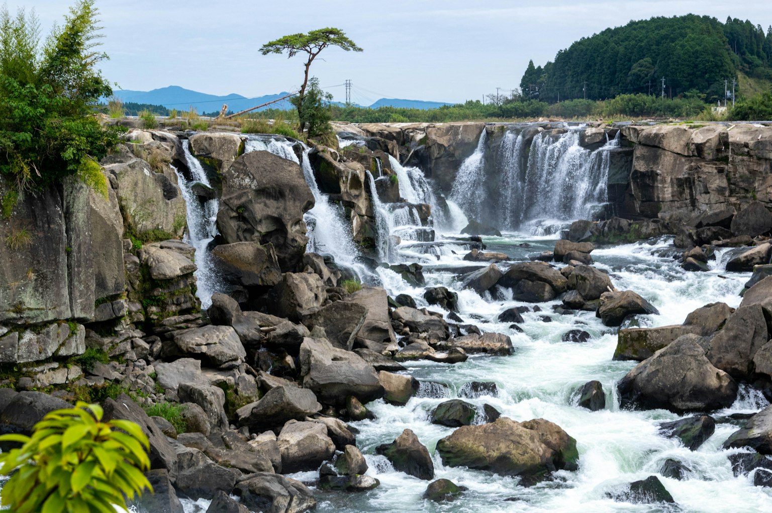 น้ำตกที่สวยงามไหลผ่านหินในทิวทัศน์ธรรมชาติ