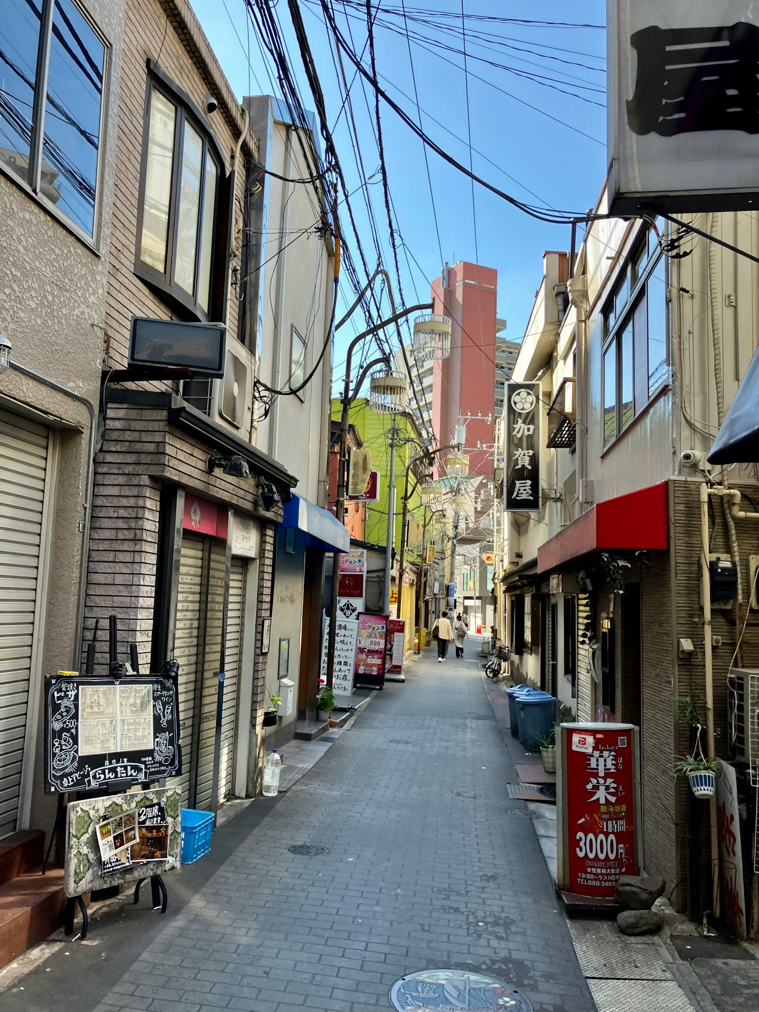 狭窄的小巷旁边是商店和对比鲜明的高楼大厦