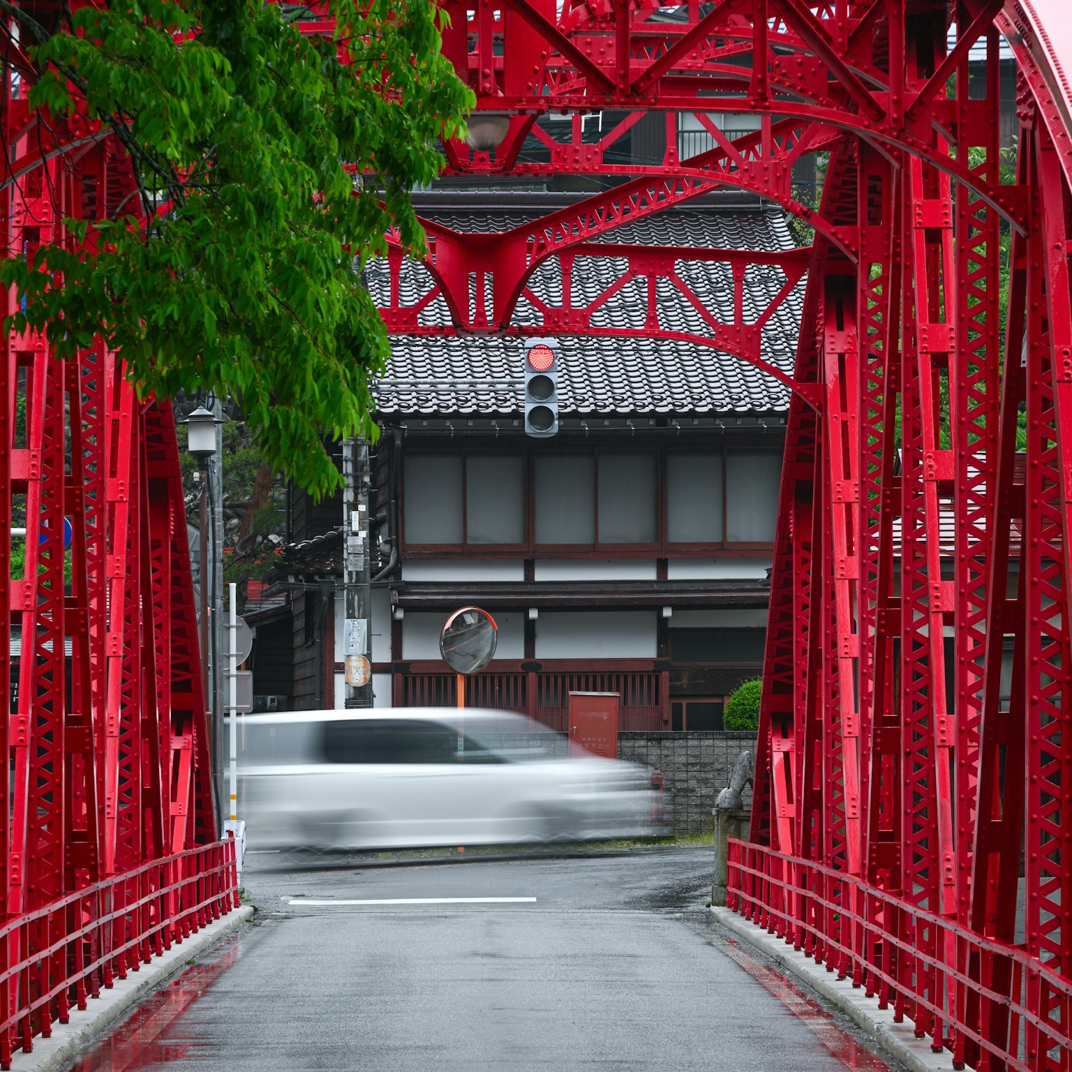 赤い鉄橋と背景の伝統的な日本の建物を含む風景