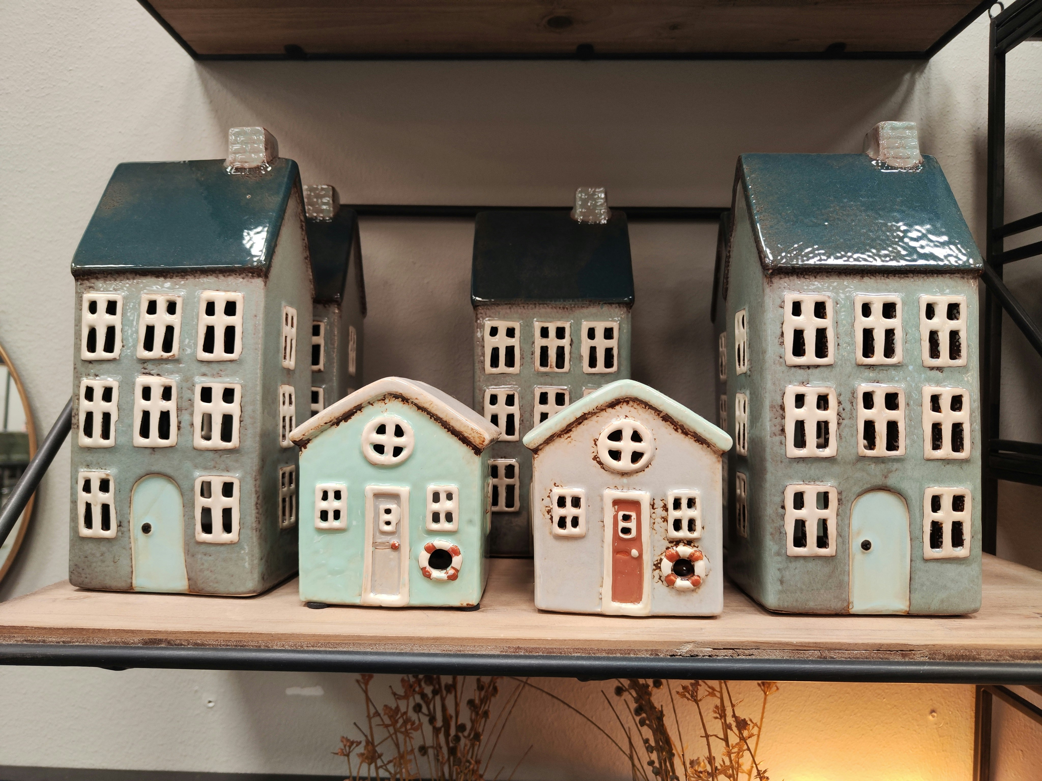 miniature houses lined up on a shelf