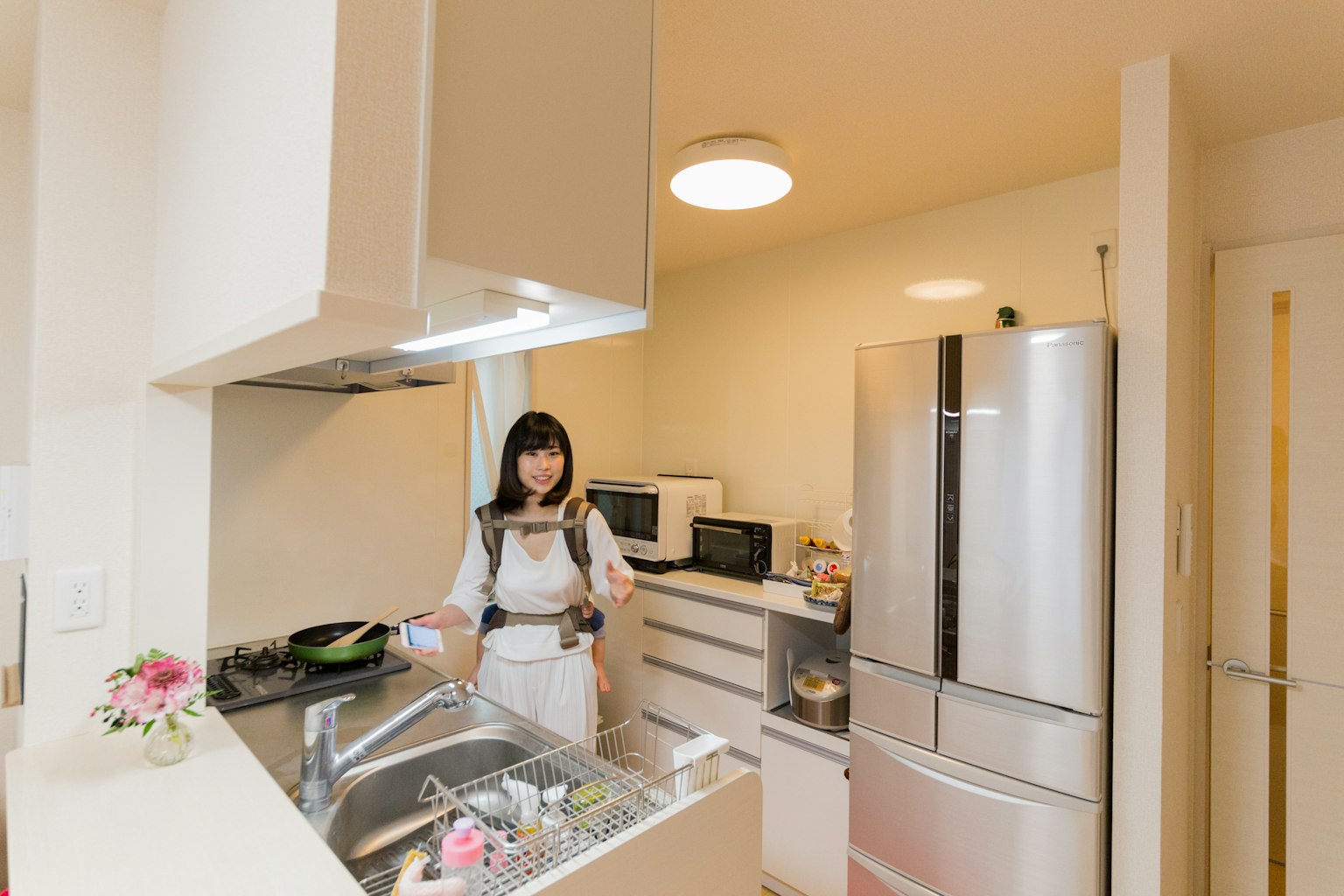 Une femme cuisinant dans une cuisine lumineuse avec des appareils modernes
