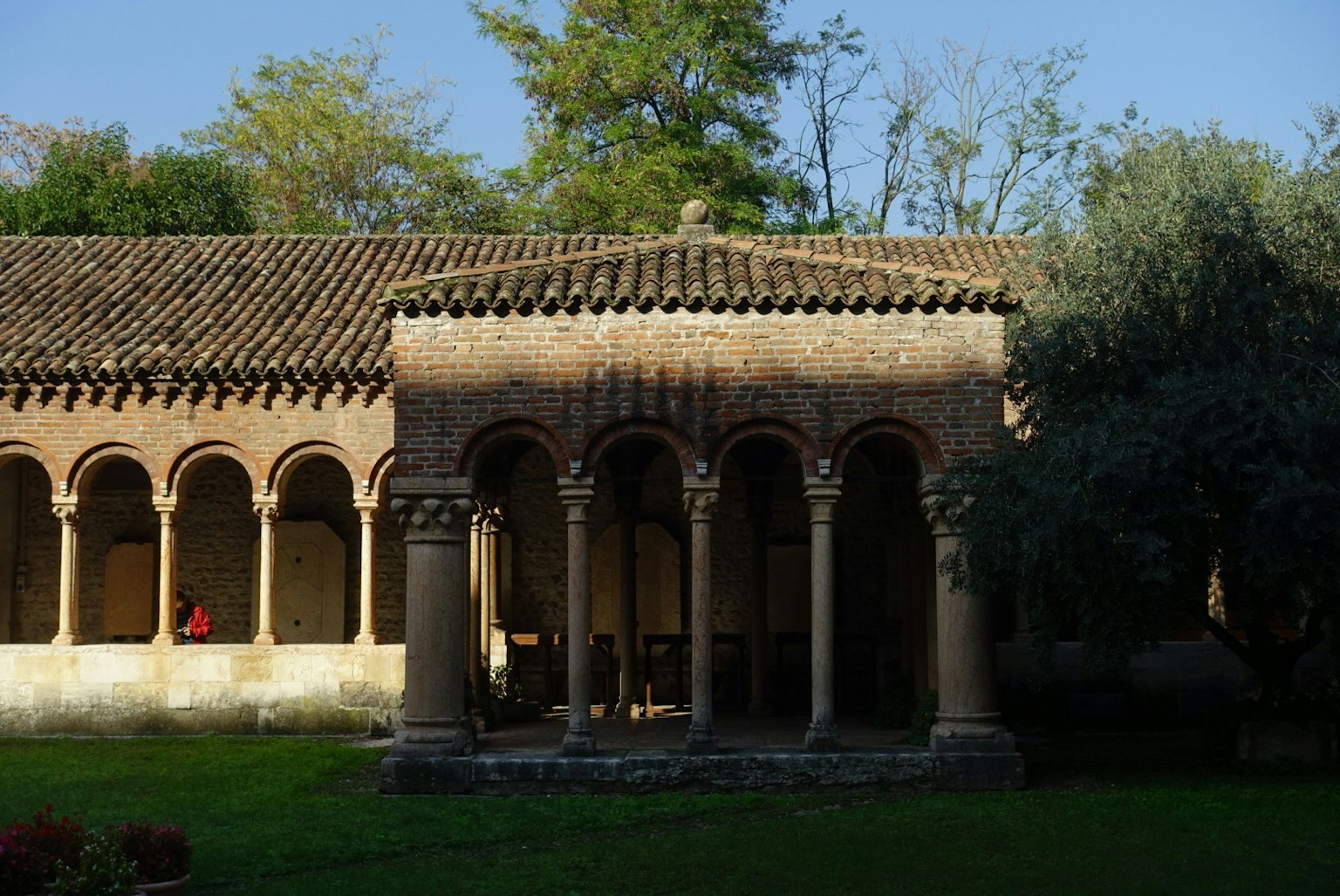 Vista di un vecchio edificio con un'arcata e colonne in un cortile