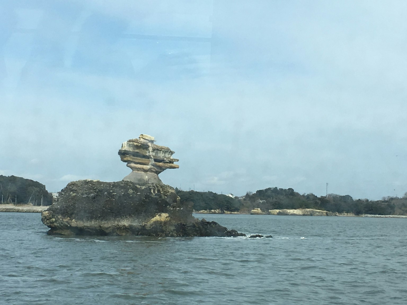 独特的岩石结构漂浮在水面上，顶部有一个小结构
