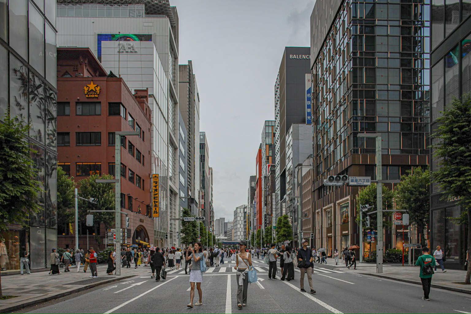 Strada affollata a Tokyo con pedoni e moderni edifici lungo il percorso