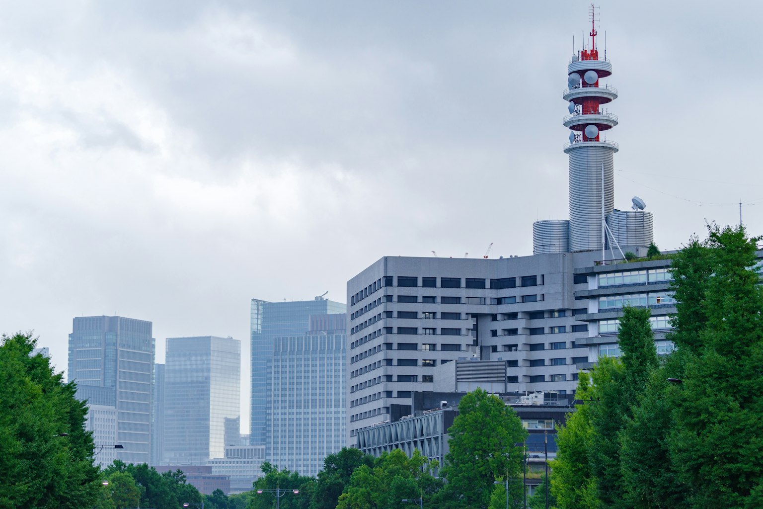 Skyline cittadina con edifici e torre di comunicazione in una giornata nuvolosa