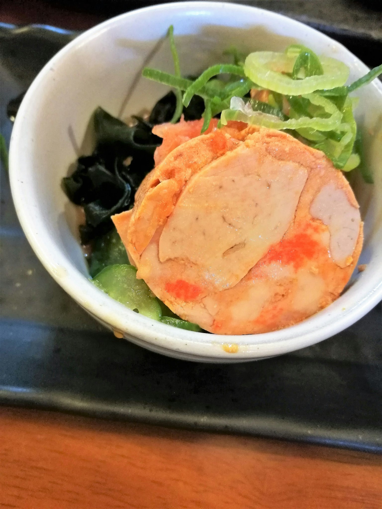切片鱼饼配海藻和绿色蔬菜