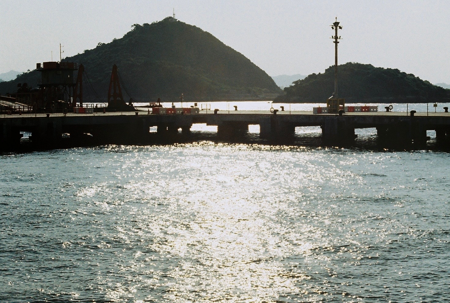 海上の防波堤と小さな灯台のある風景