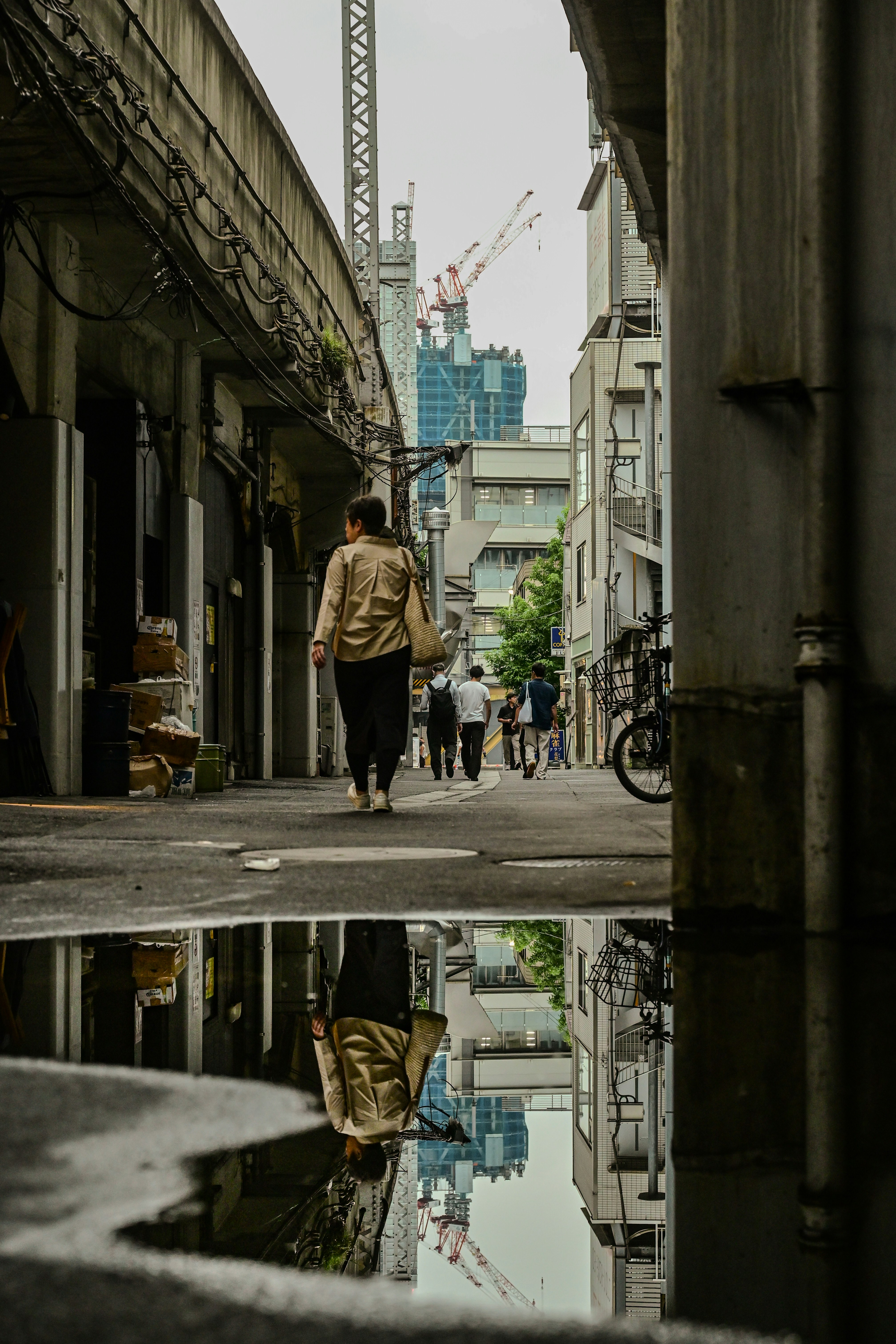 路地の奥へ続く自転車と人のいる街並み
