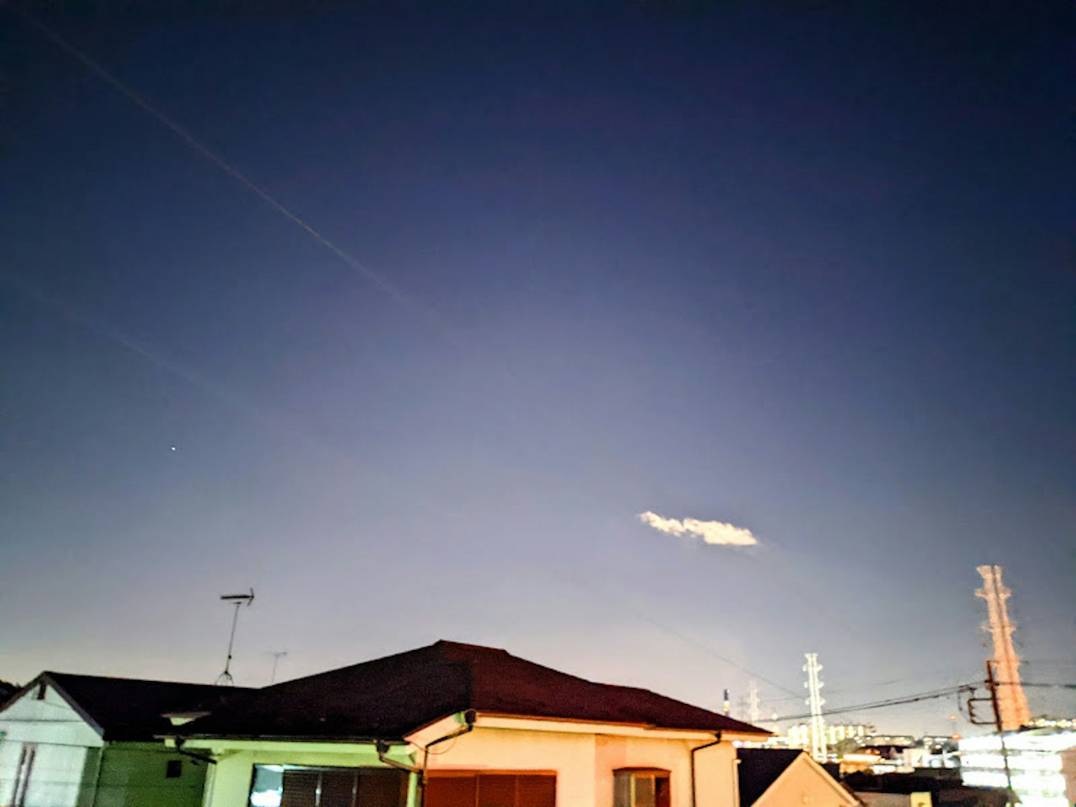 Cielo nocturno con una nube y casas a la vista
