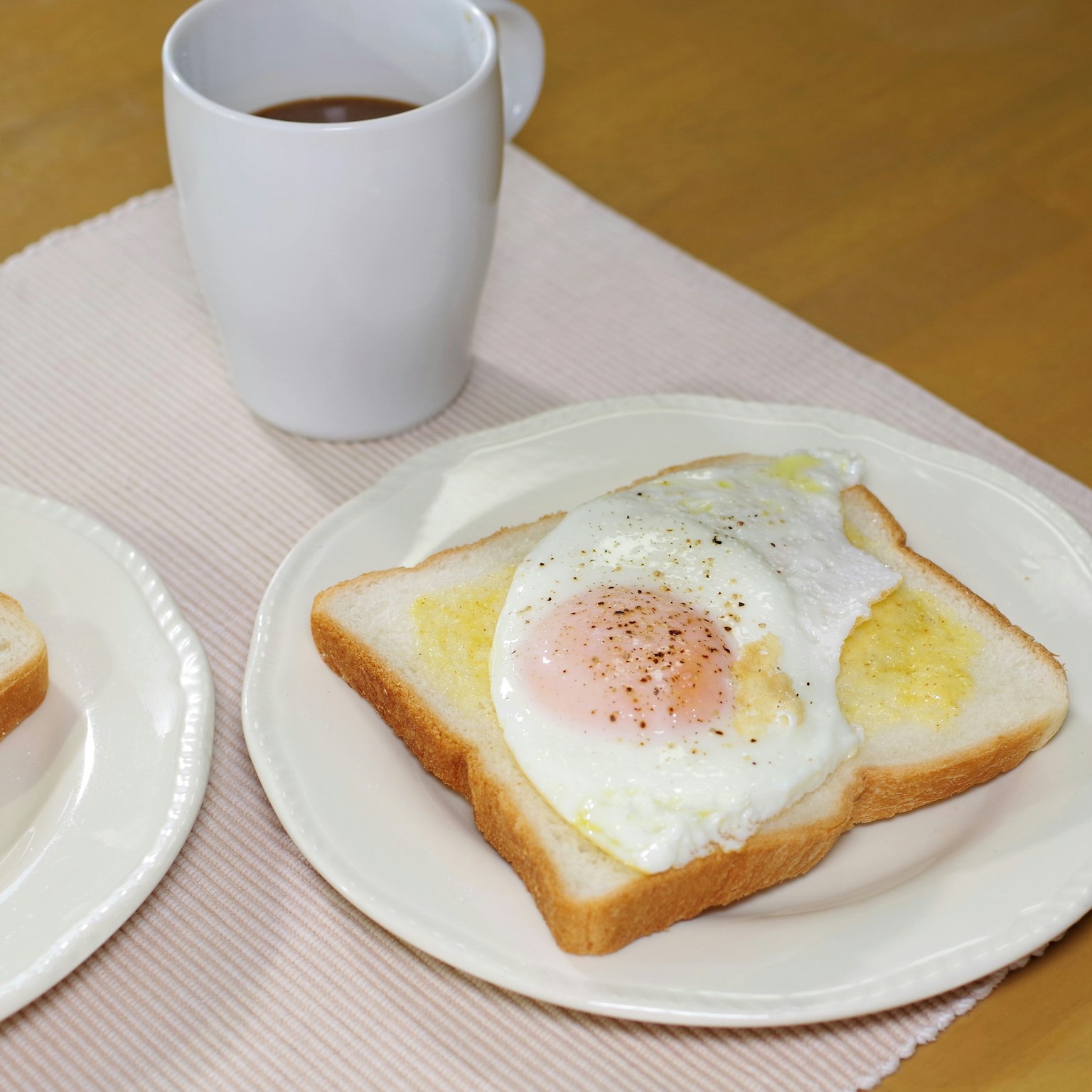 早餐盤上有烤吐司和煎蛋，還有一杯咖啡