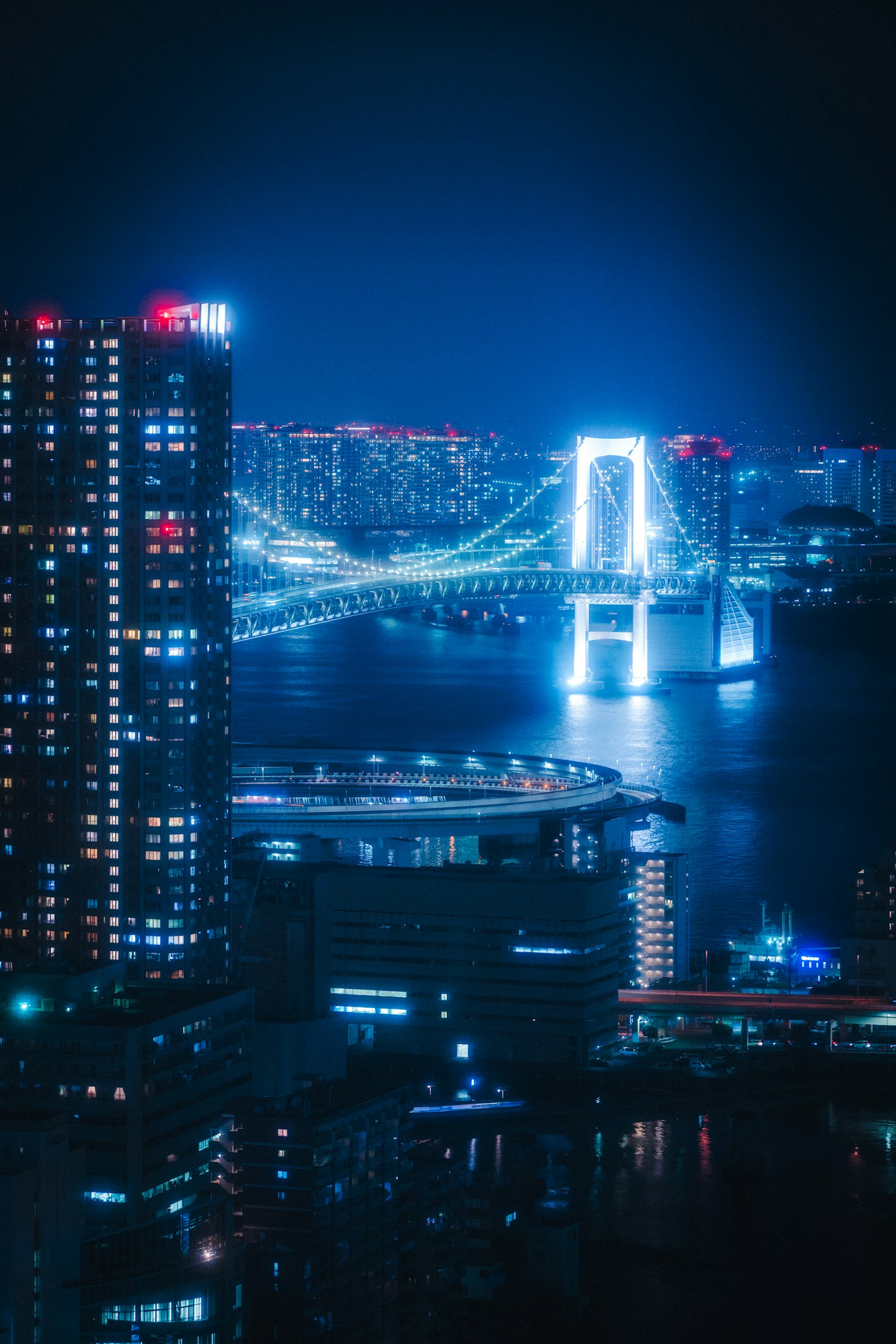 ทิวทัศน์ยามค่ำคืนที่สวยงามของสะพานเรนโบว์และตึกระฟ้าบนอ่าวโตเกียว