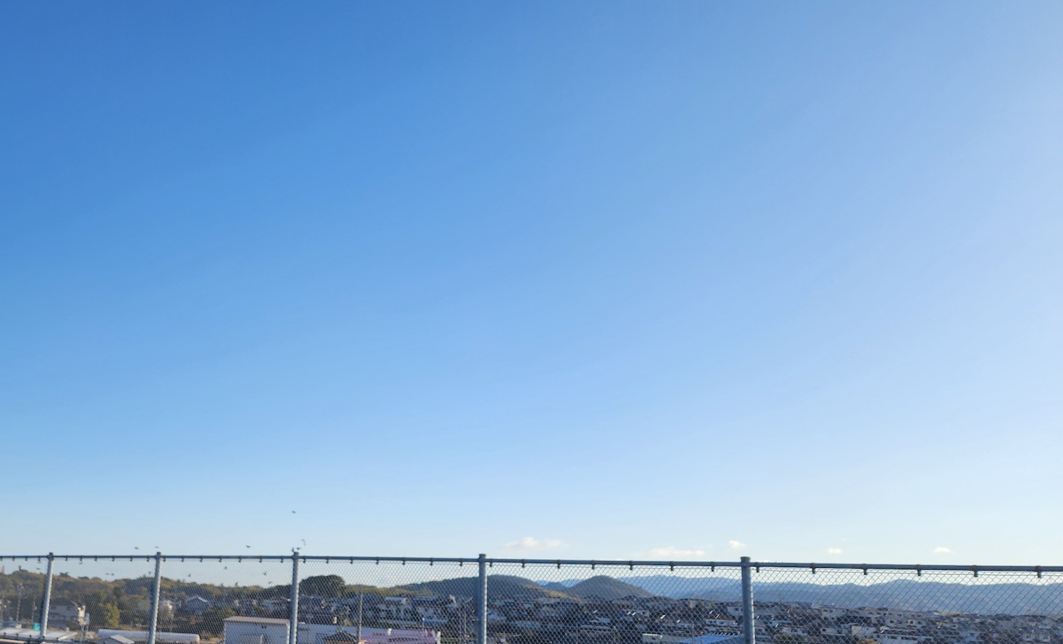 Cielo azul claro con una cerca en primer plano