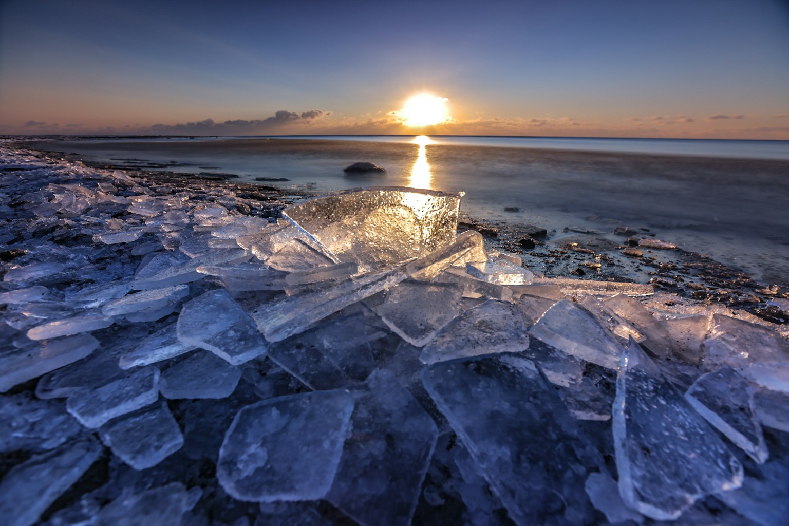 Paesaggio con frammenti di ghiaccio e un tramonto sul mare
