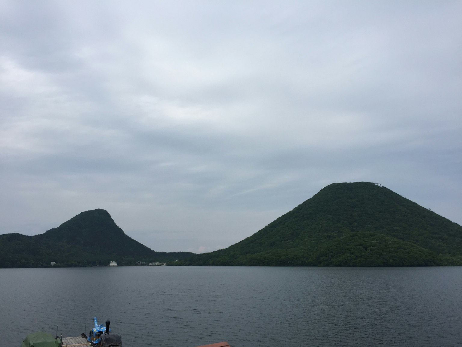 Paesaggio di montagne e lago con cielo nuvoloso e colline verdi
