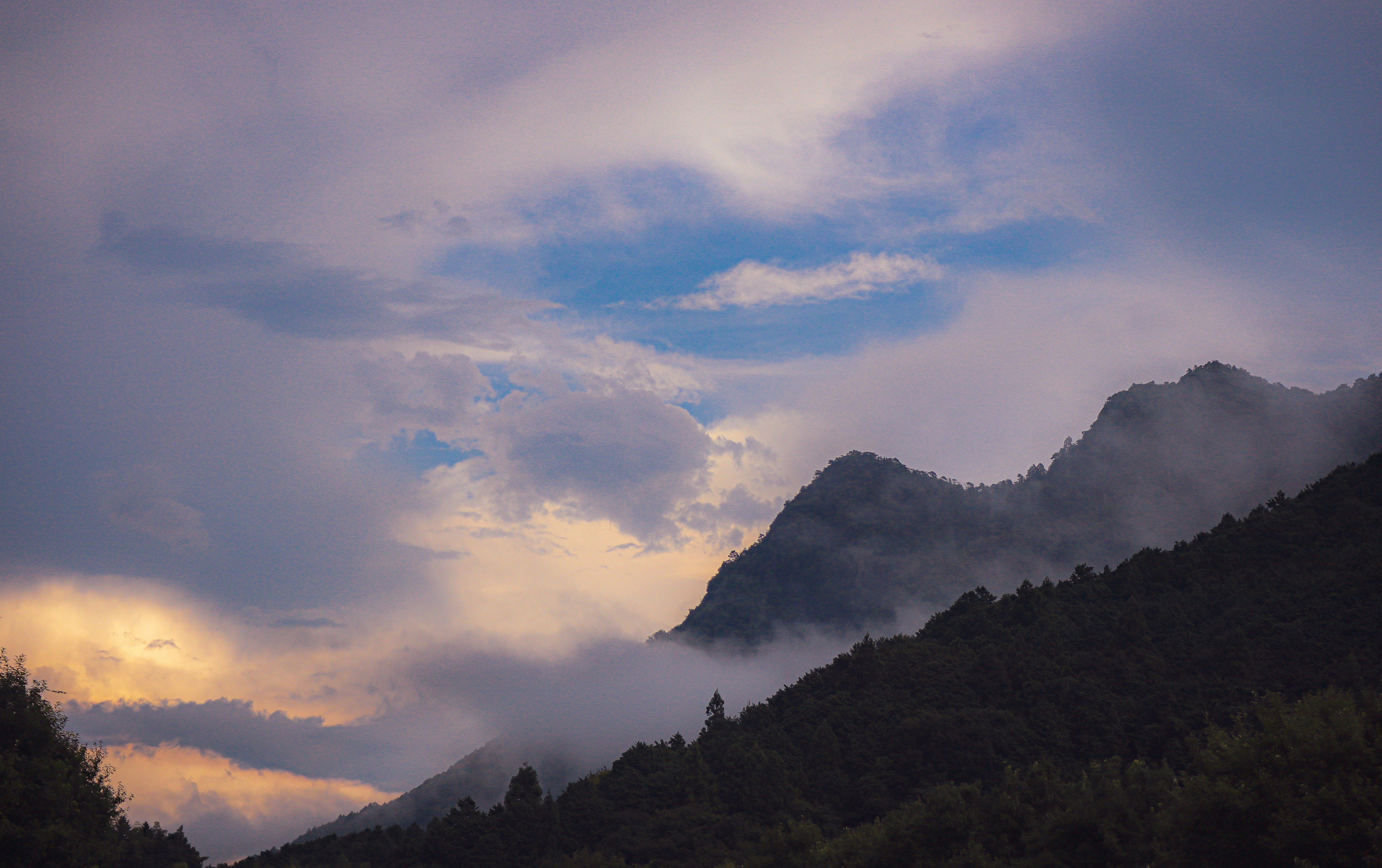 山霧のかかった夕焼けの山稜と森の稜線