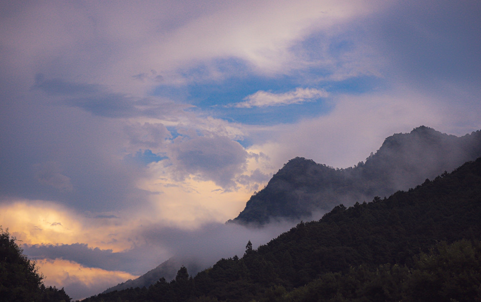 Paisaje montañoso con nubes al anochecer