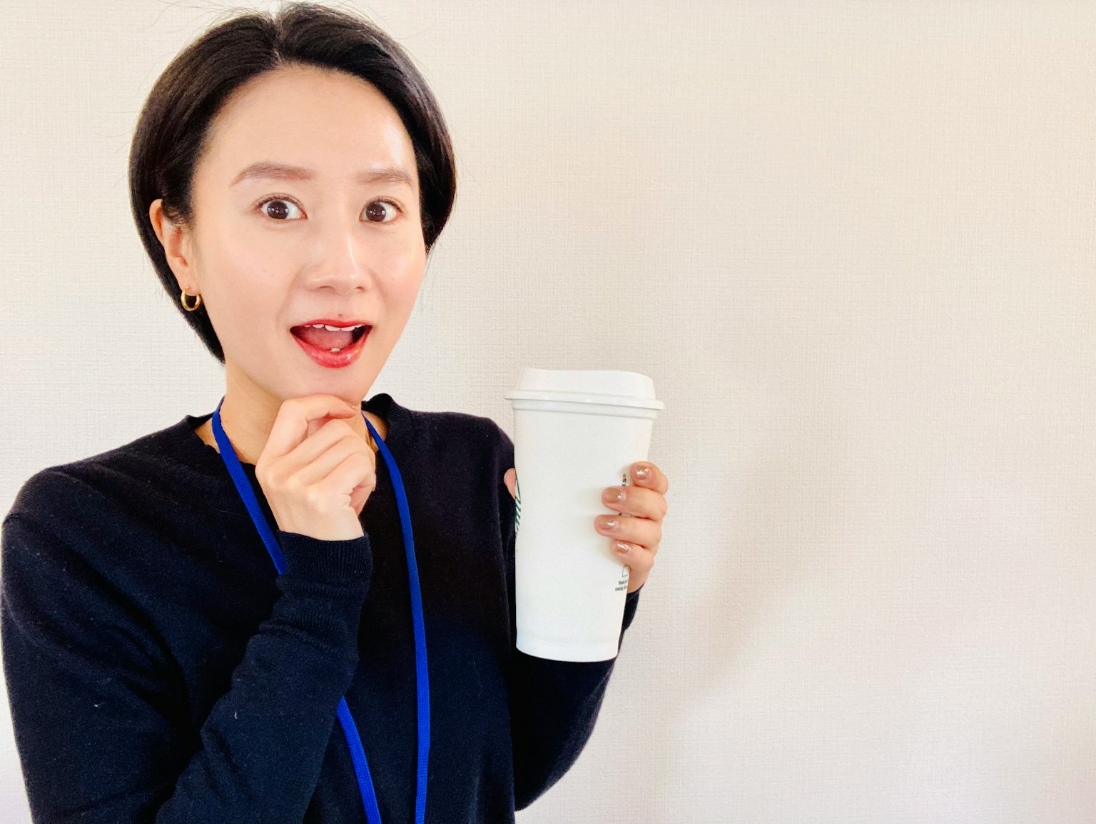 一位驚訝的女性手持白色咖啡杯