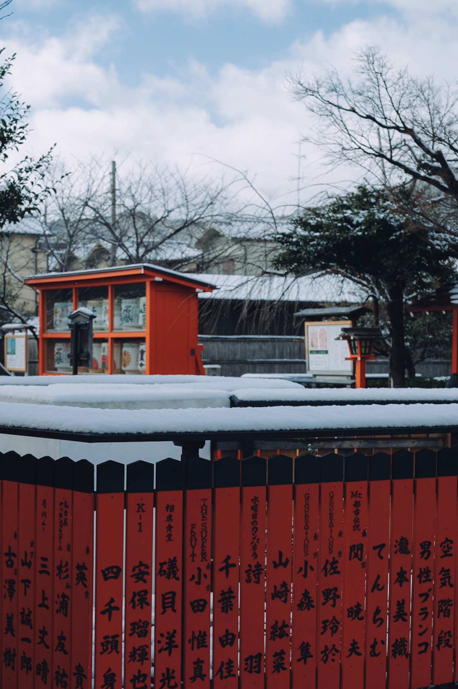 雪覆盖的红色围栏和背景建筑的冬季景象