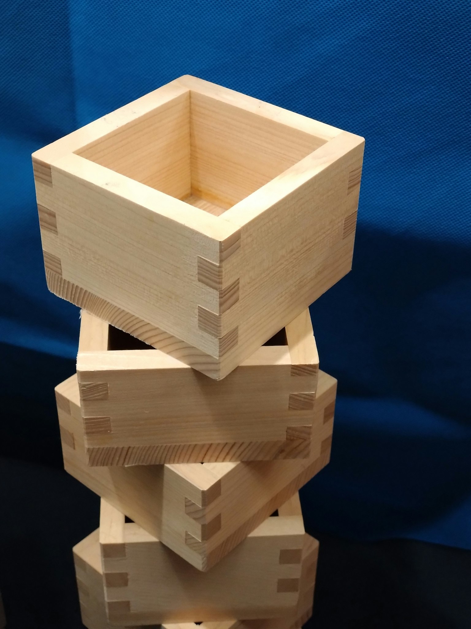 Stack of wooden boxes with a square shape against a blue background