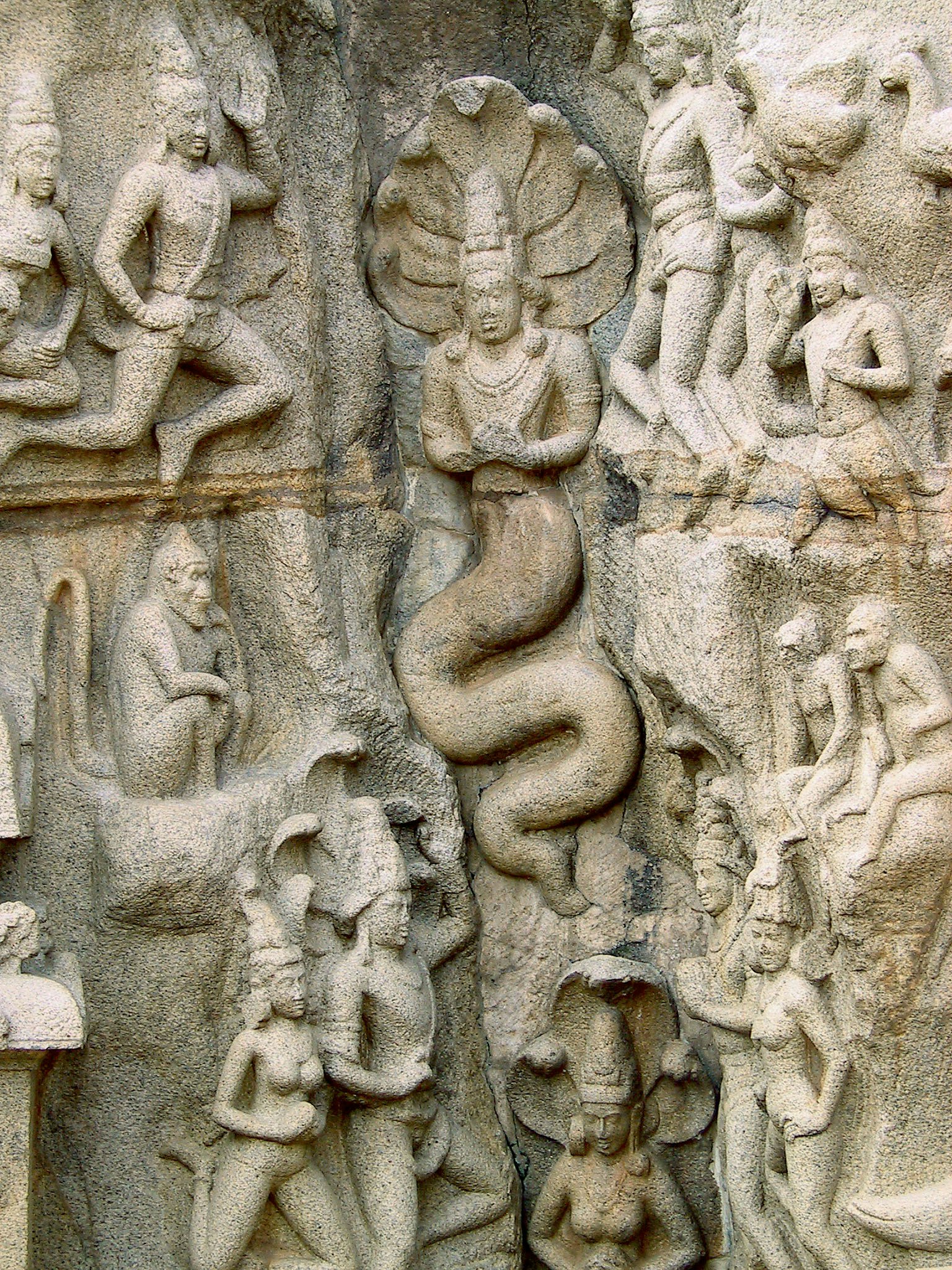 Ancient stone wall carvings depicting deities and a serpent god