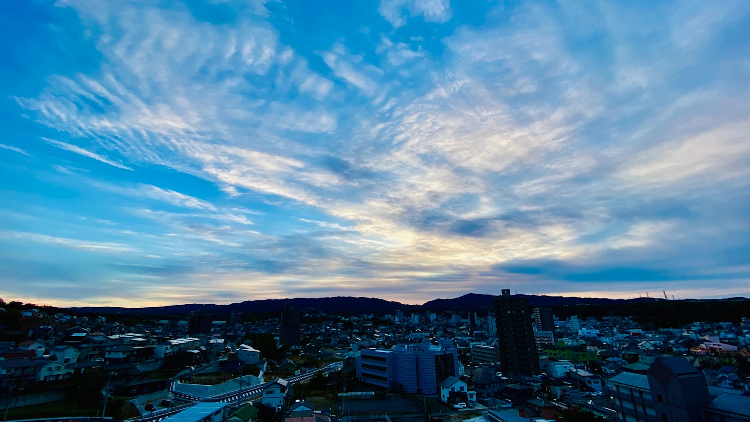 Panoramablick auf eine Stadtlandschaft unter einem blauen Himmel mit Wolken