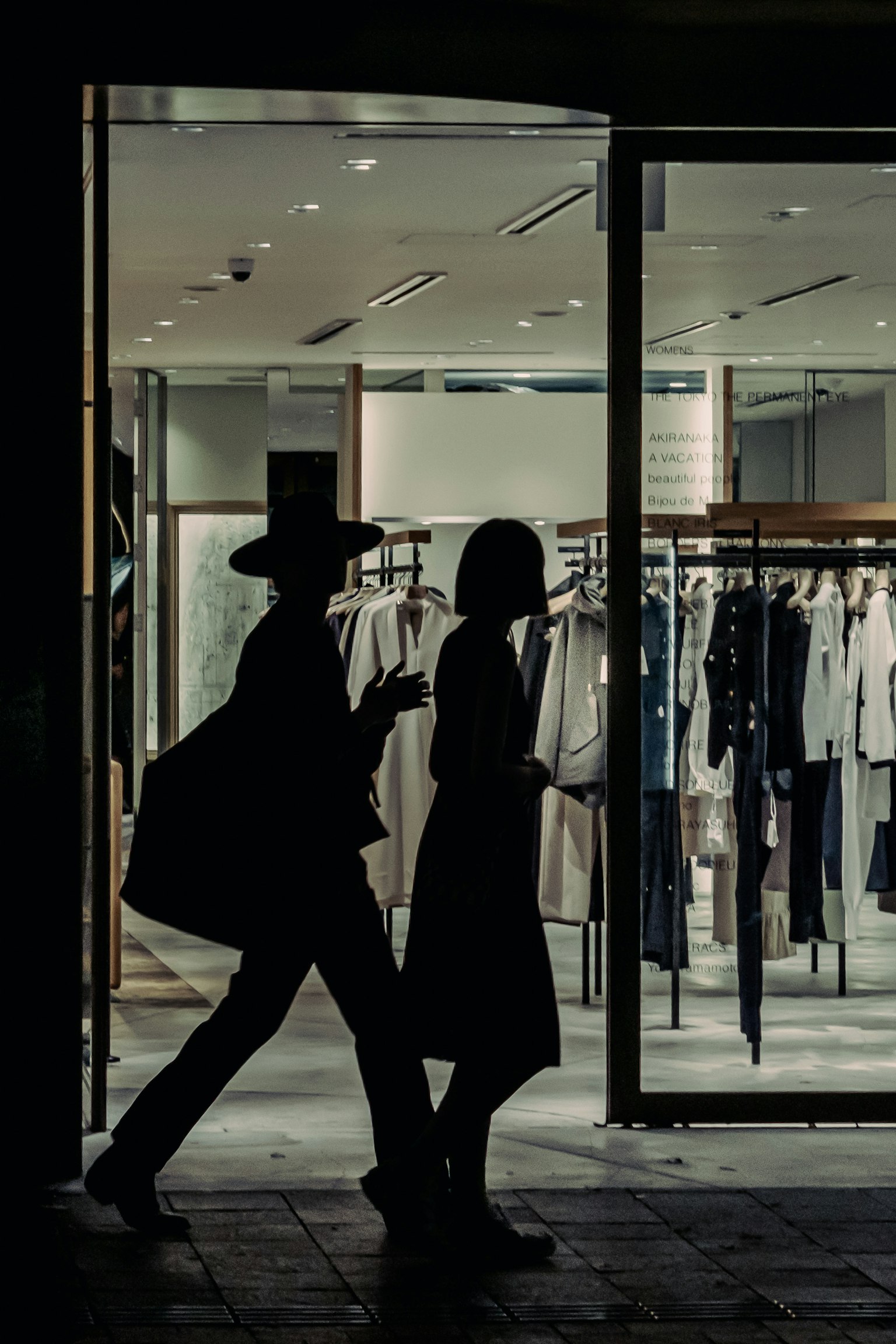 Bóng người đi qua cửa hàng quần áo