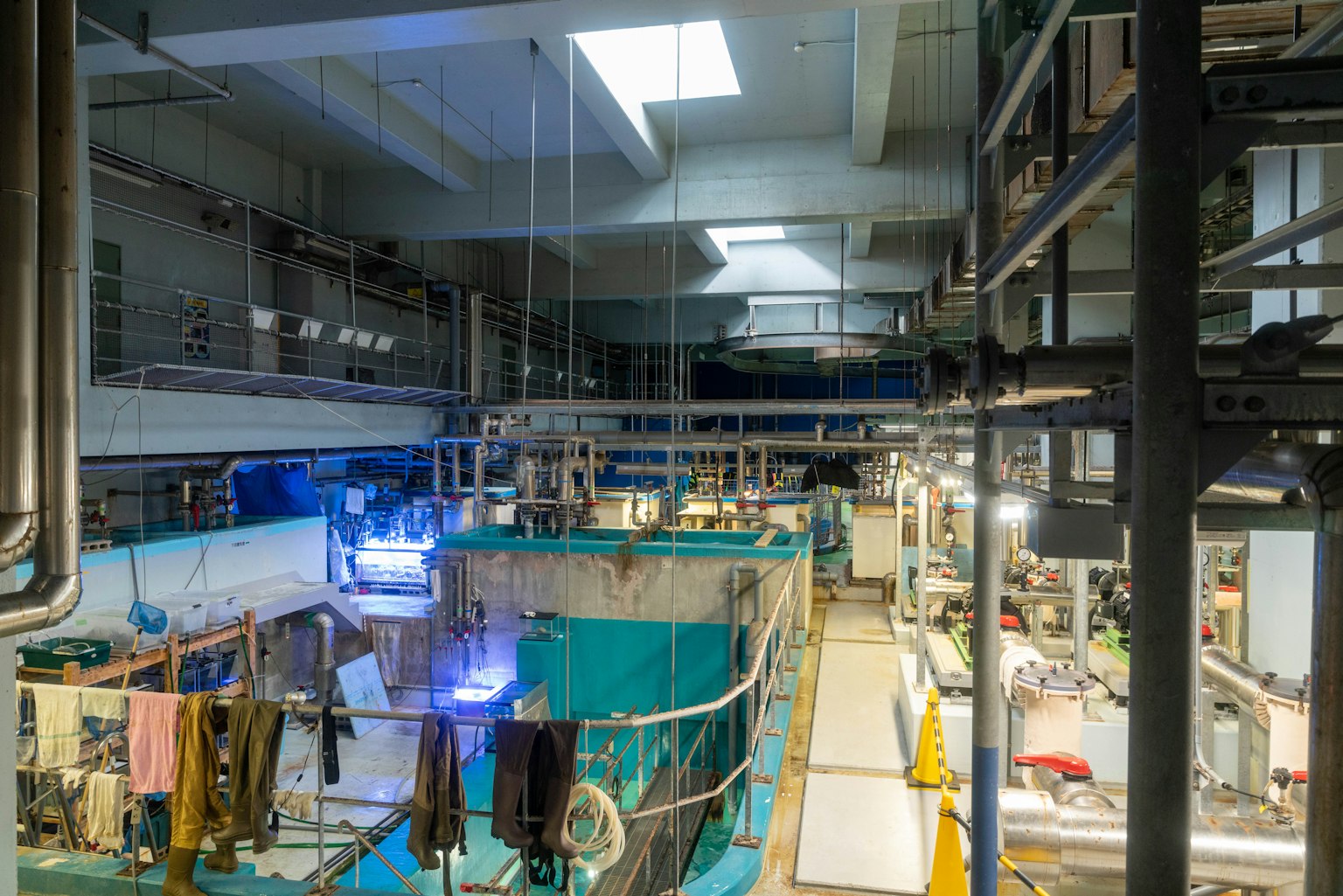 Vue aérienne d'une installation industrielle avec des réservoirs bleus et un éclairage