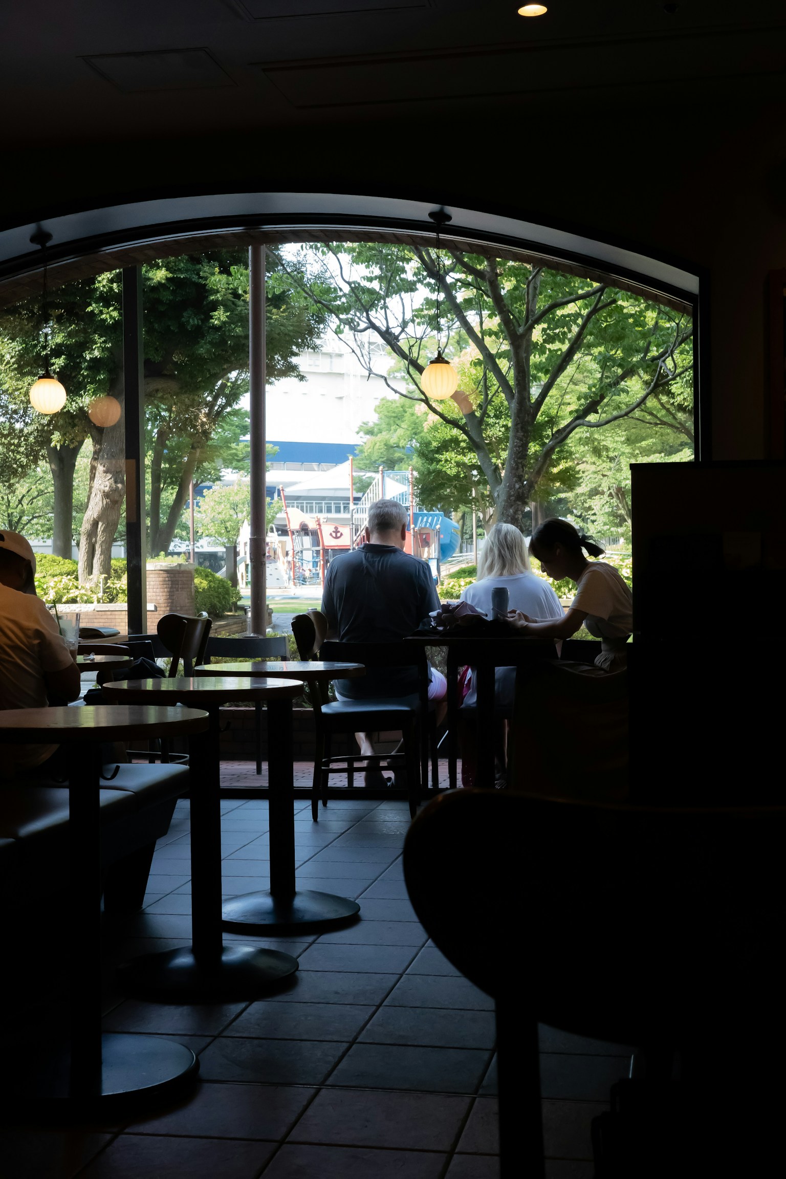 Vista da una finestra di caffè che mostra alberi e persone all'esterno