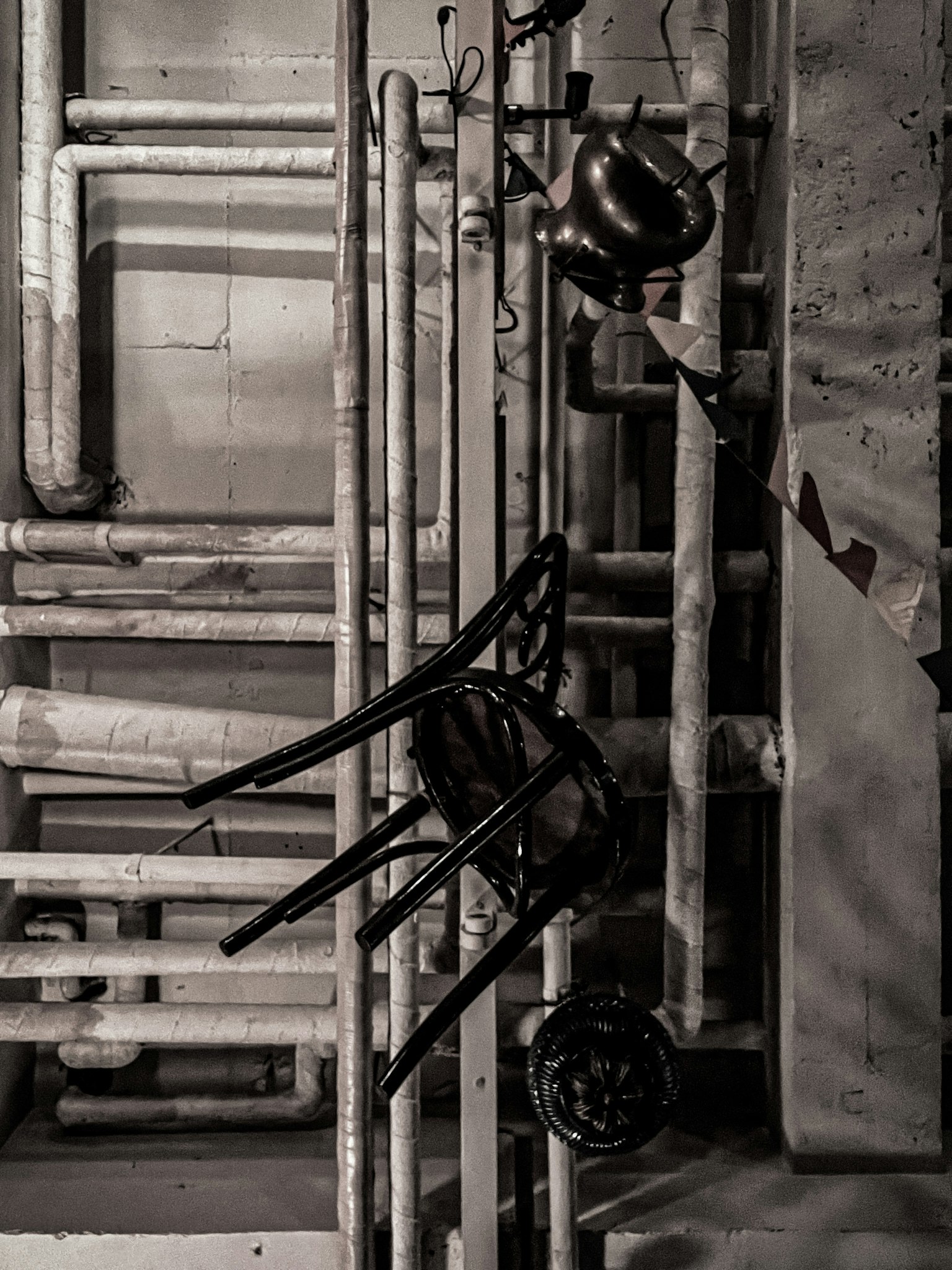 Fond industriel avec des tuyaux et une chaise noire
