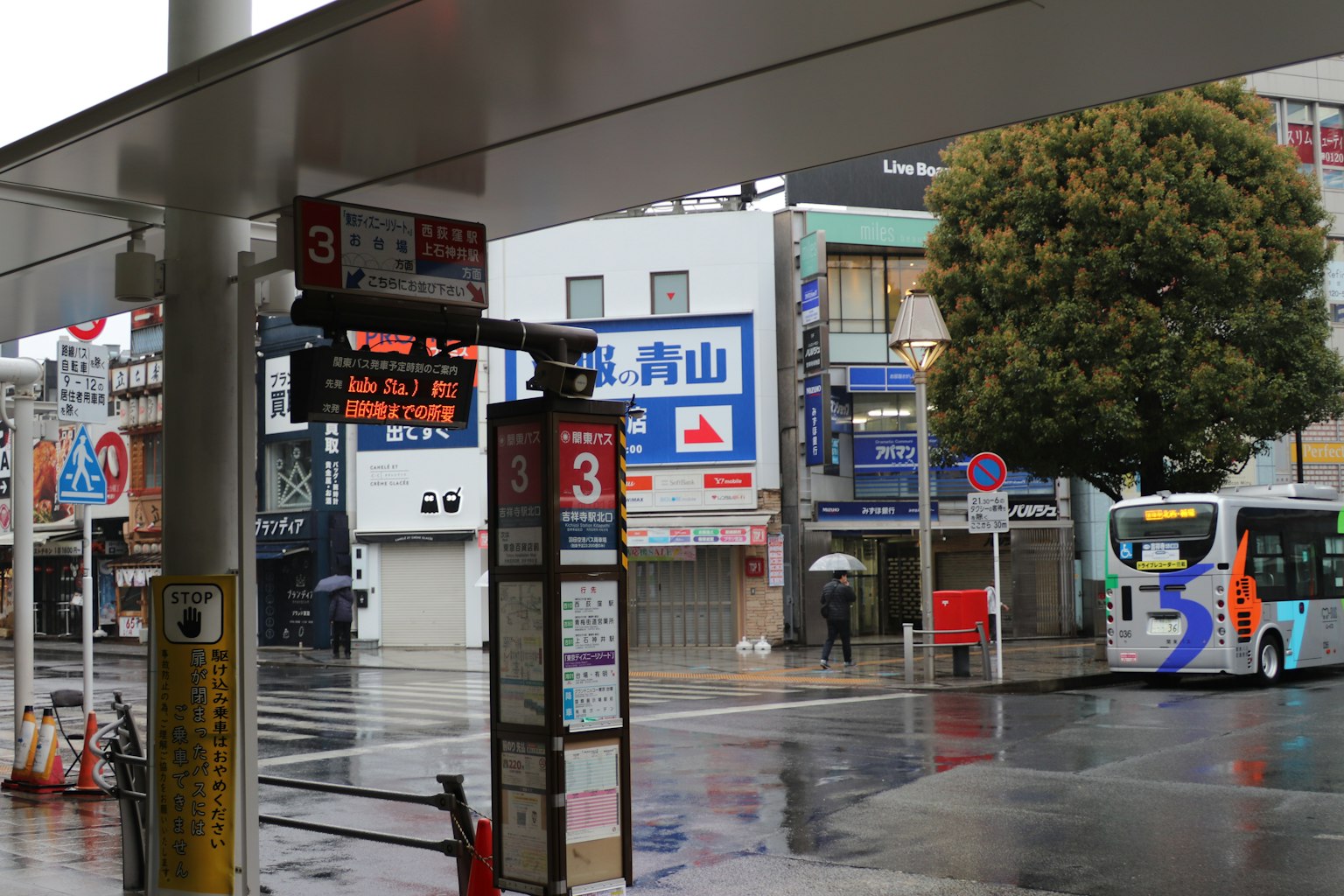 Scena di fermata dell'autobus in un giorno di pioggia con segnale di destinazione visibile