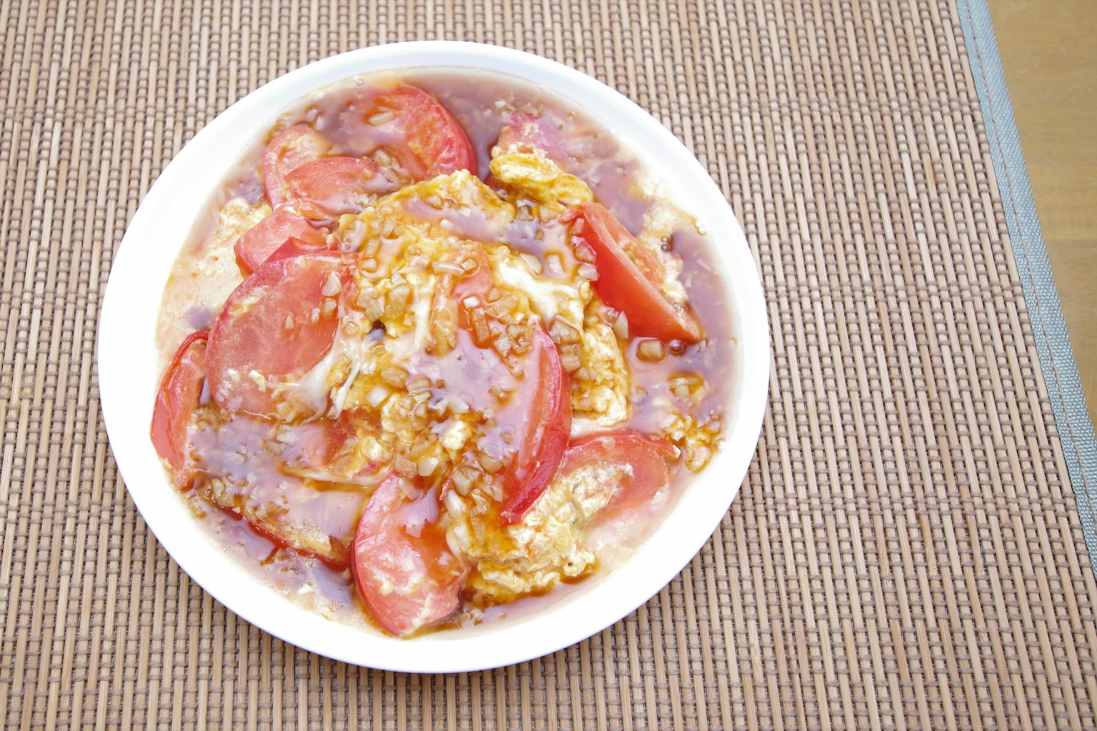 Ein weißer Teller mit einem Gericht aus Tomaten und Eiern in Soße
