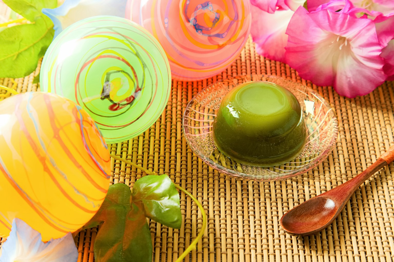 Cốc thạch đầy màu sắc và trang trí hoa trên bàn với món thạch xanh