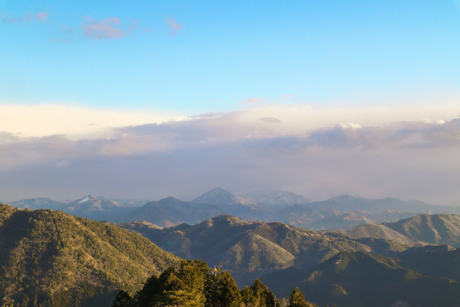 Ampio paesaggio montano sotto un cielo blu chiaro