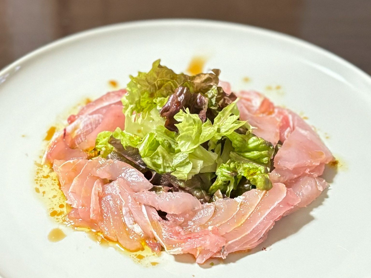 Pesce affettato sottilmente con insalata di lattuga fresca