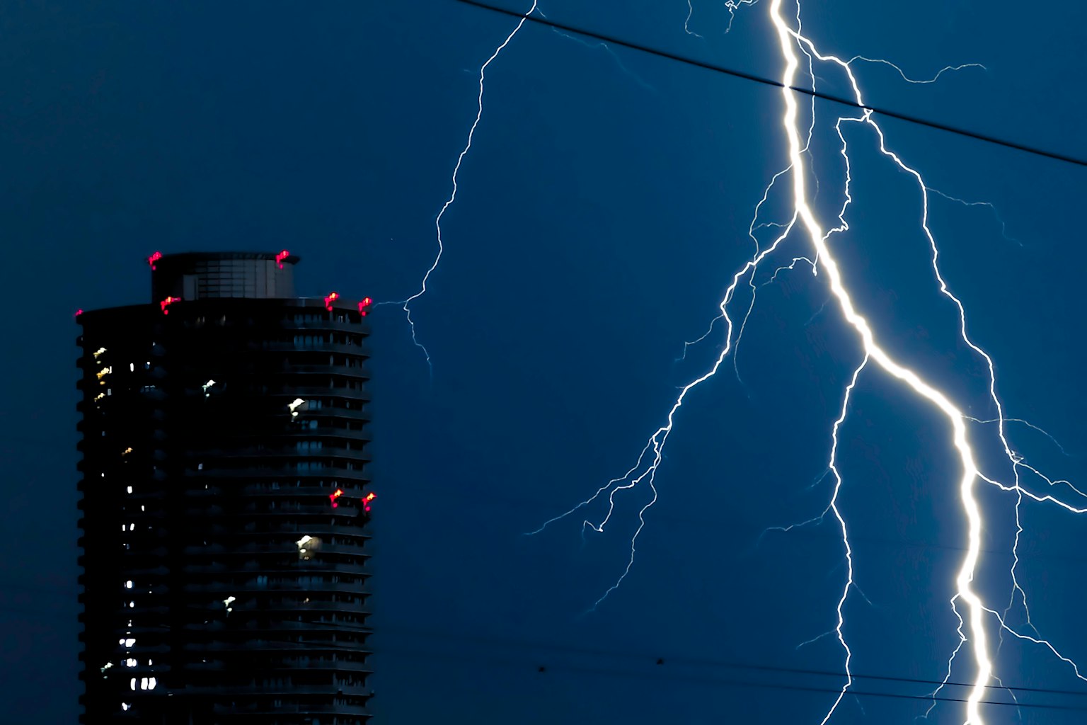 Fulmine che colpisce un cielo scuro con un grattacielo
