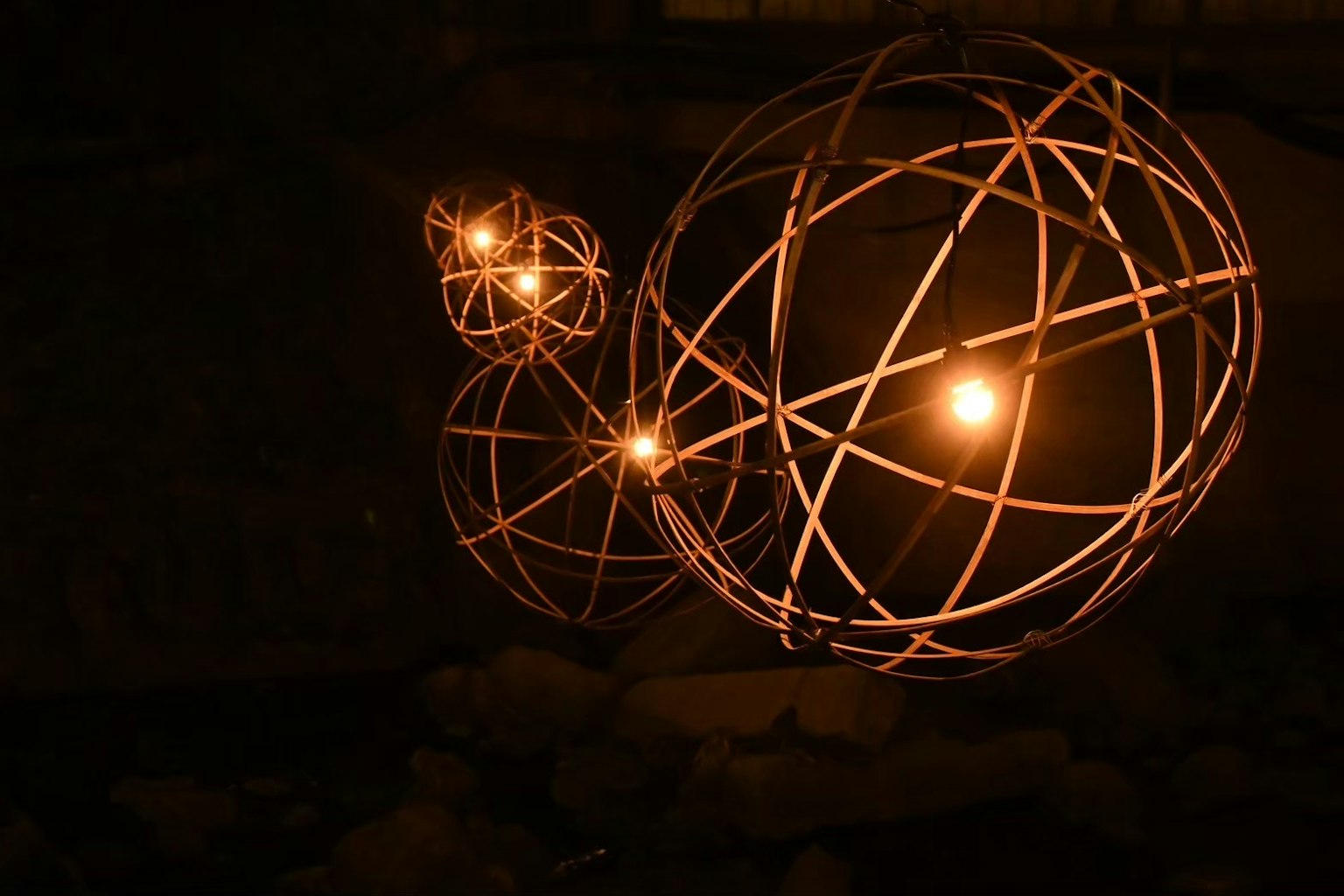Trois objets sphériques lumineux sur un fond sombre