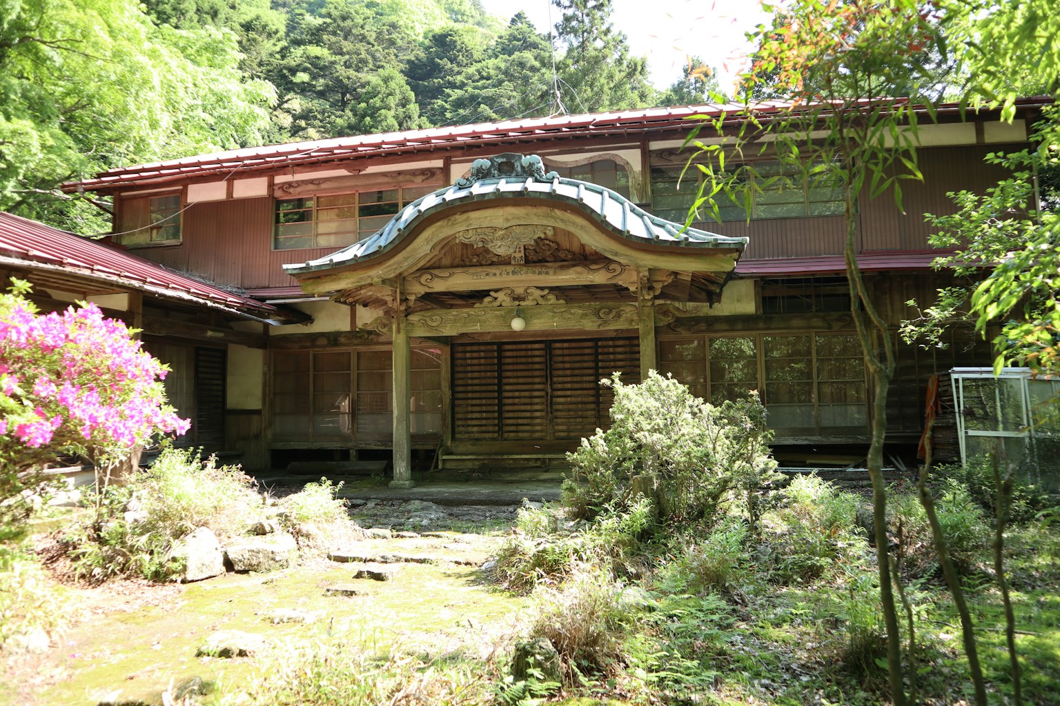 传统日本房屋和花园场景，周围有植物和花卉