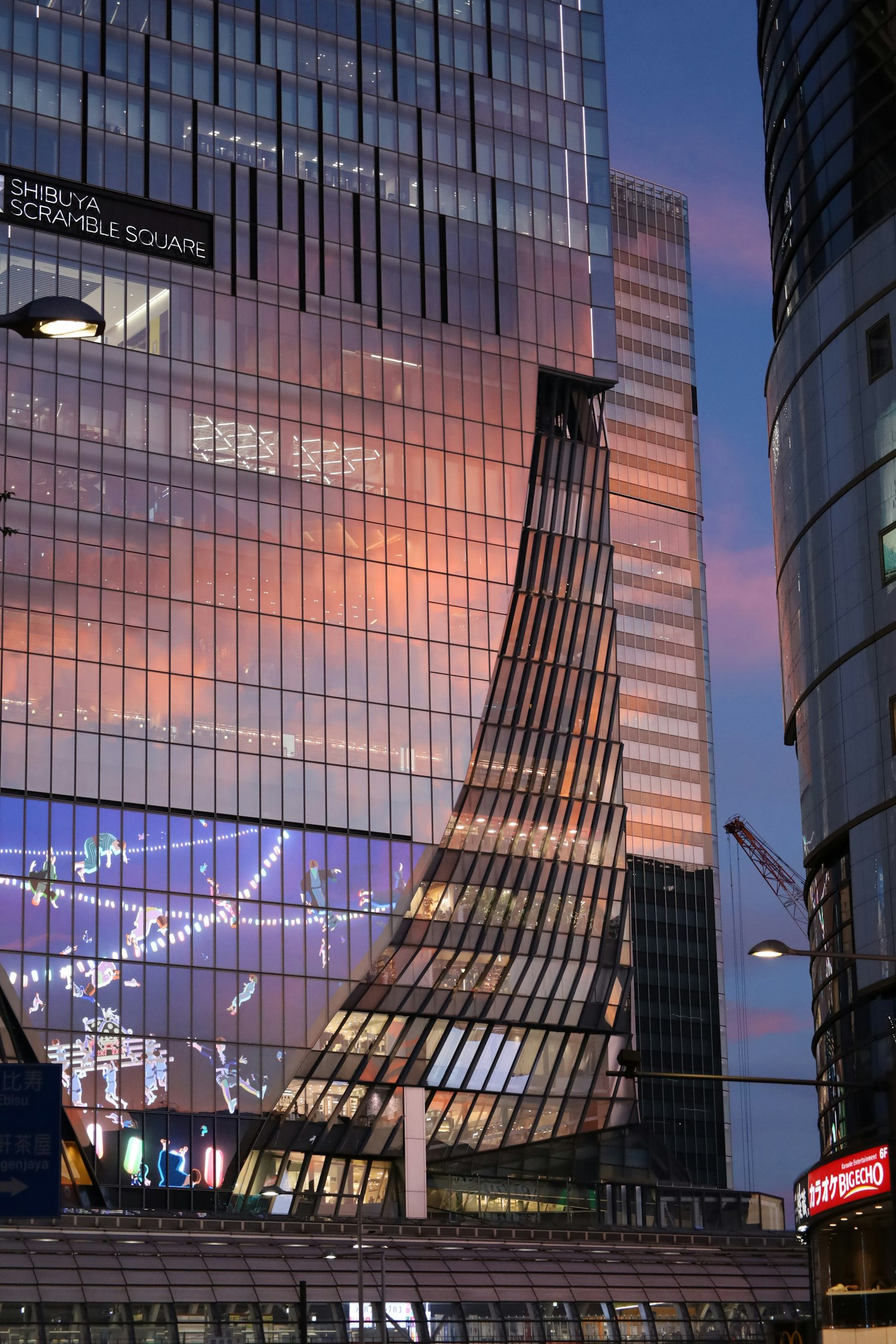 Façade moderne d'un bâtiment illuminée par le coucher de soleil Façade en verre réfléchissant Design architectural courbé