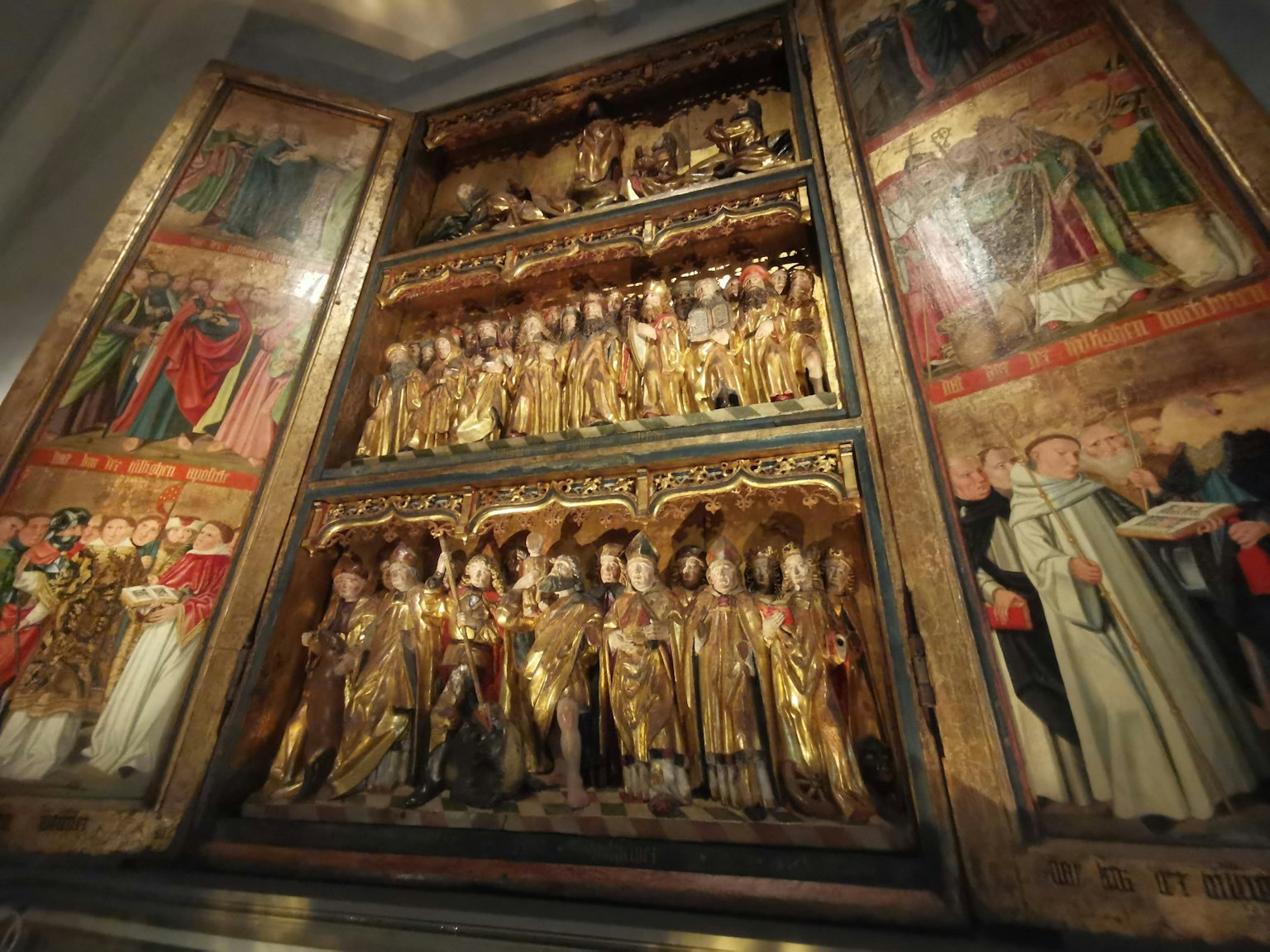 Golden sculptures and religious figures depicted in an altarpiece