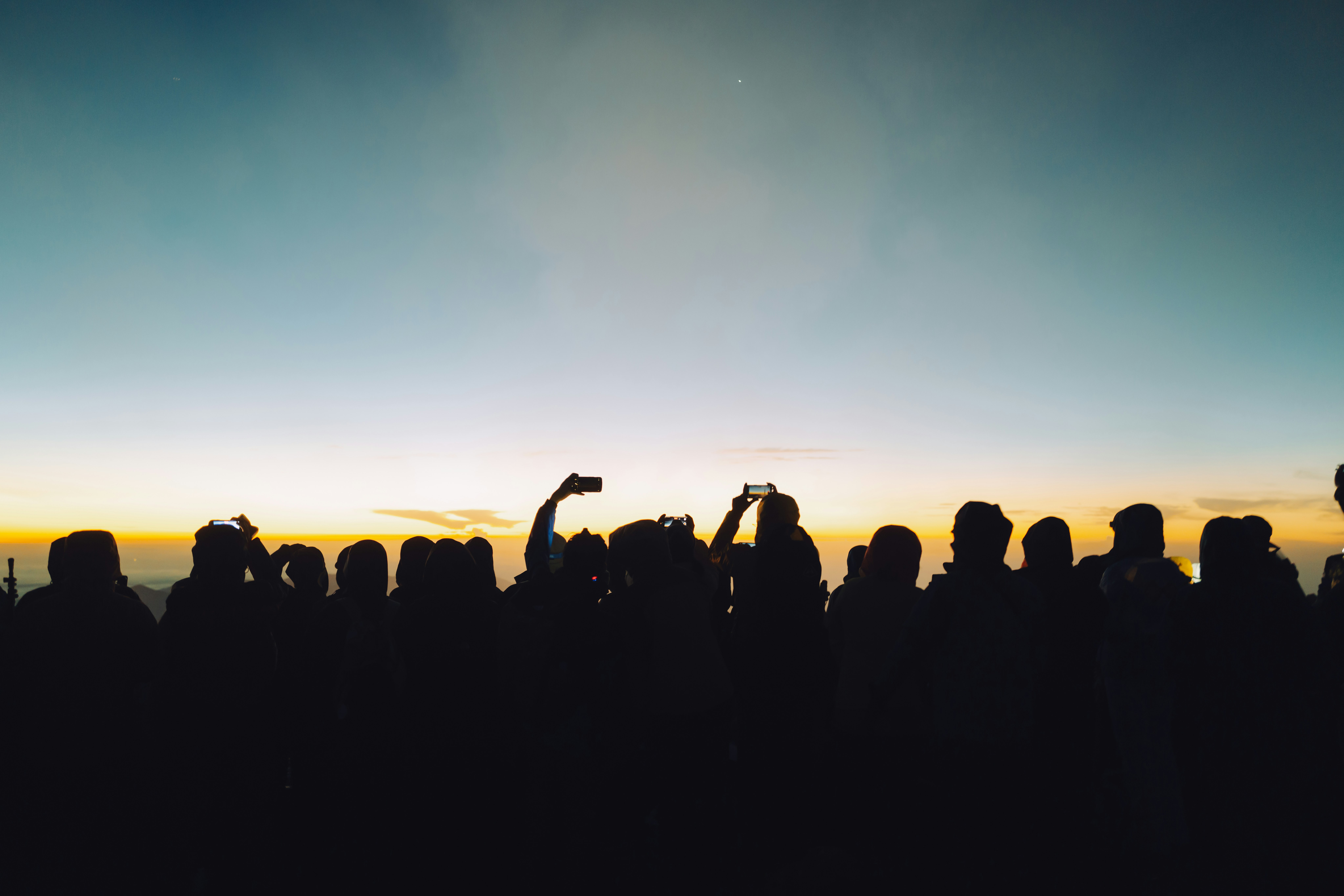 silhouettes of people against a sunset sky
