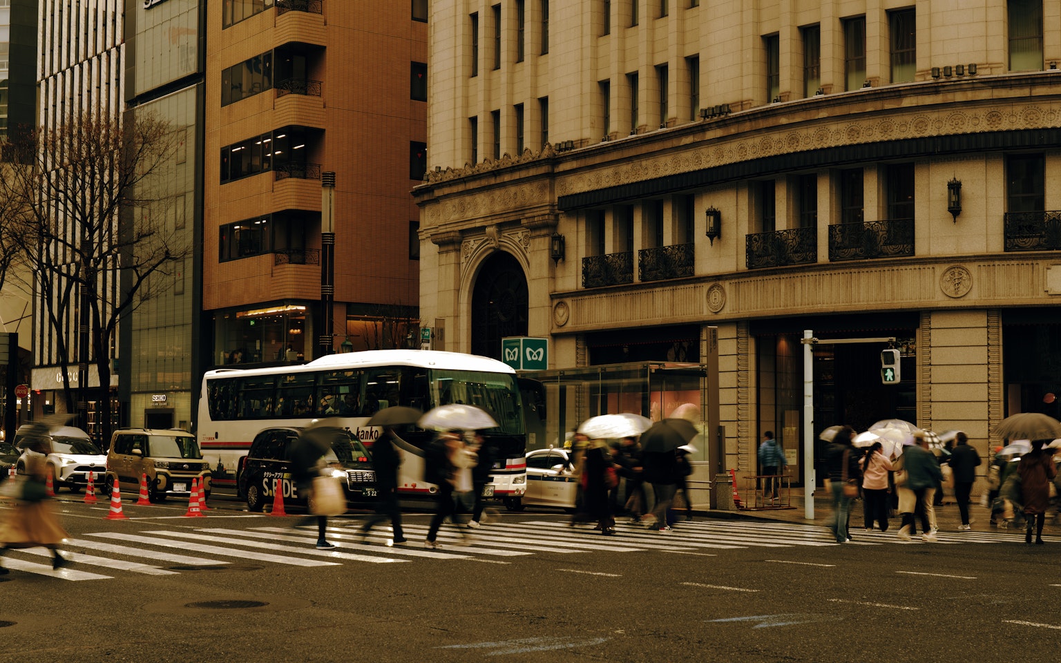 People crossing the street with umbrellas in a city scene