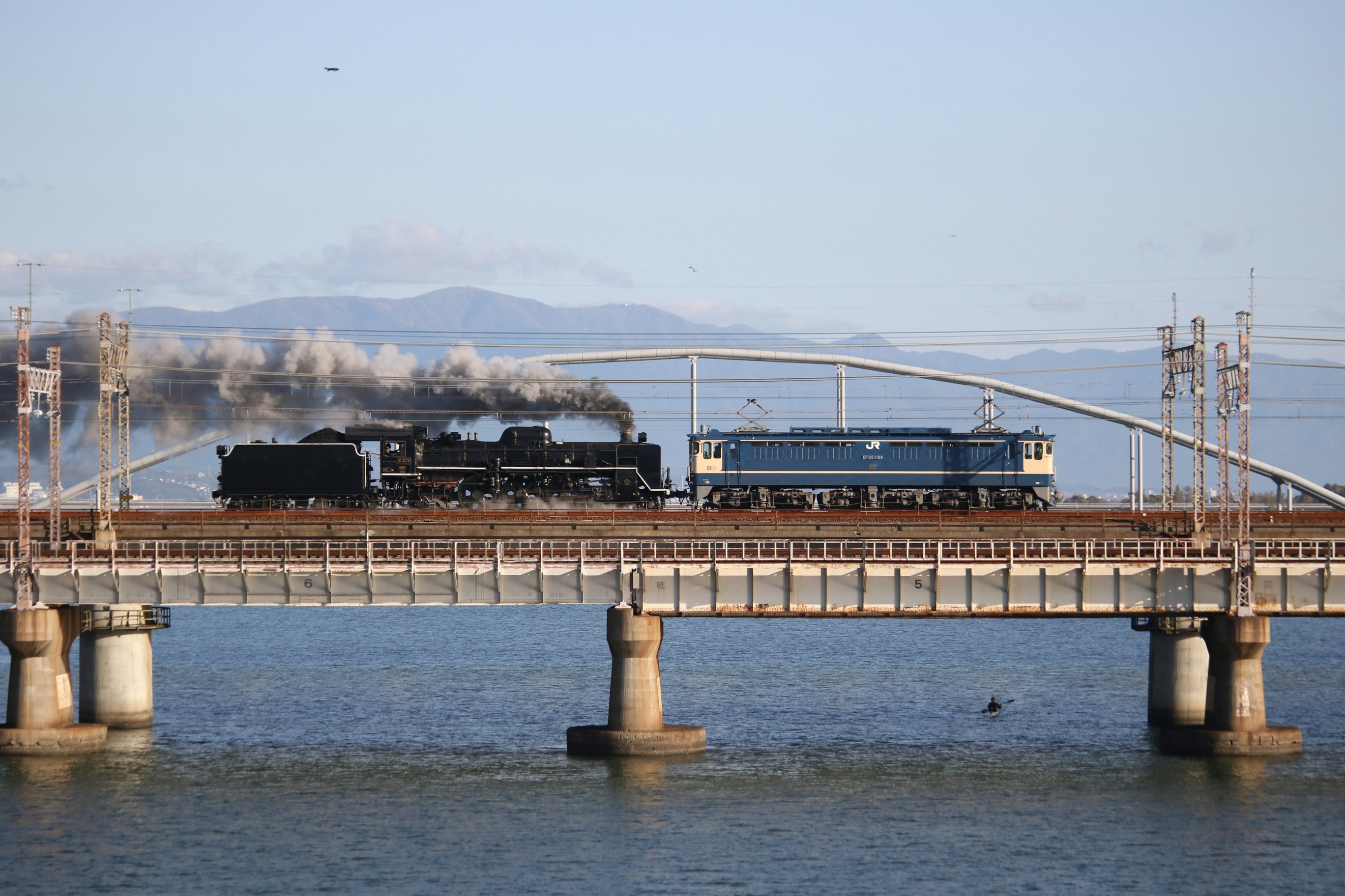 cargo train crossing a bridge over the sea