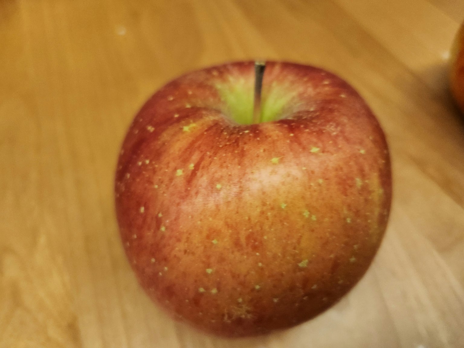 一顆紅蘋果放在木桌上