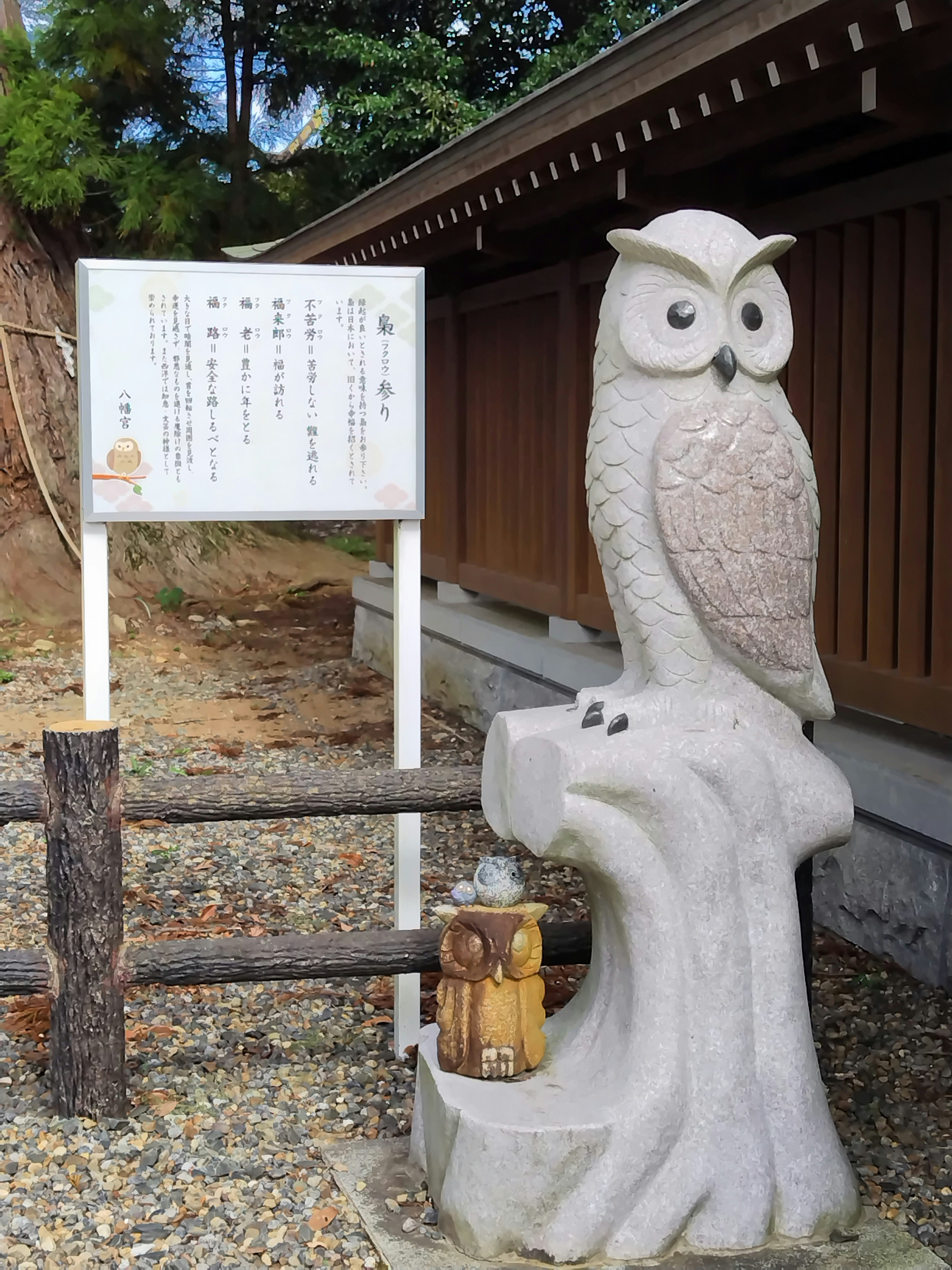 ふくろうの石像が置かれた屋外の小道