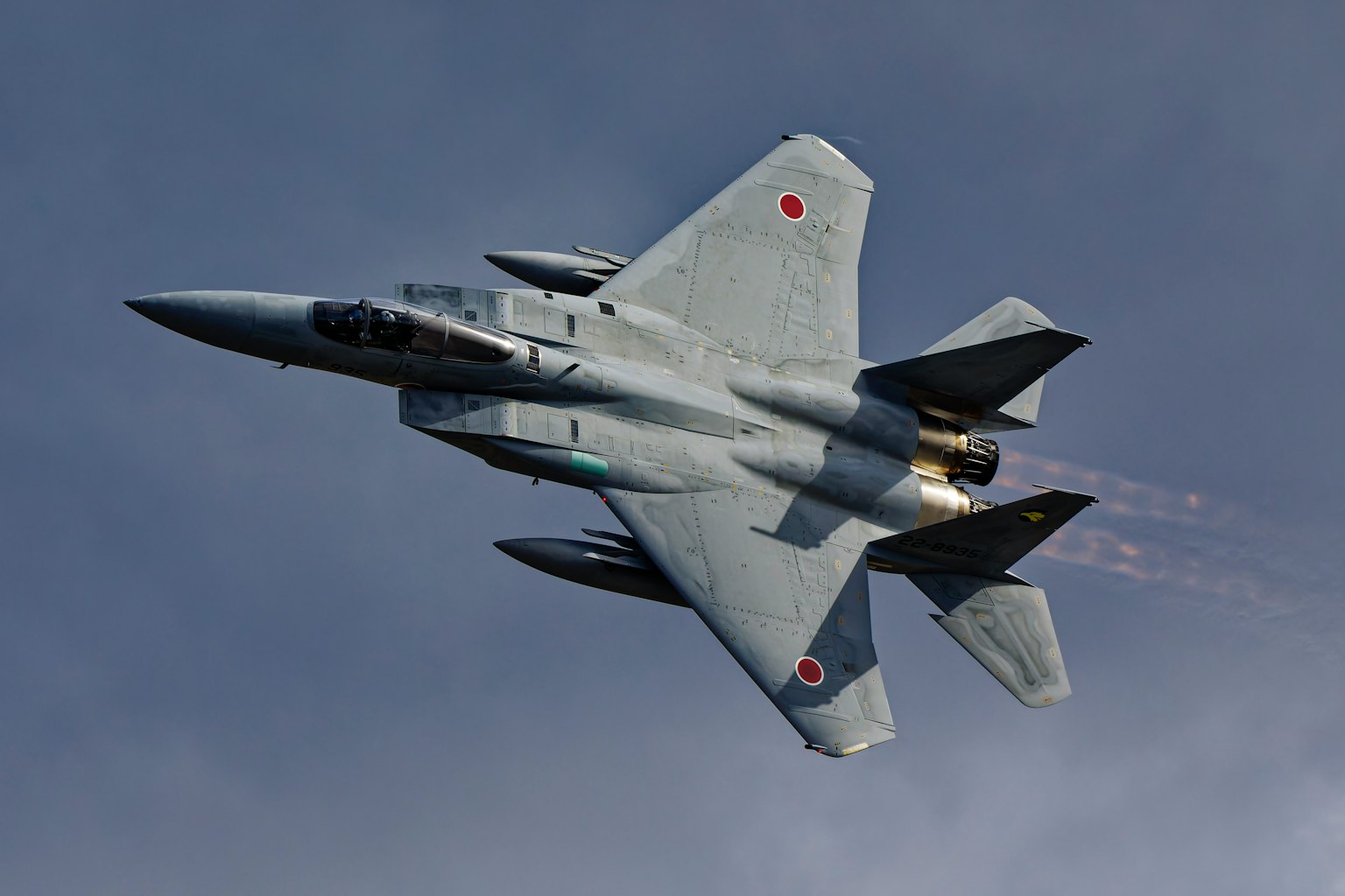 Japanese F-15 fighter jet soaring through the sky with visible exhaust flames
