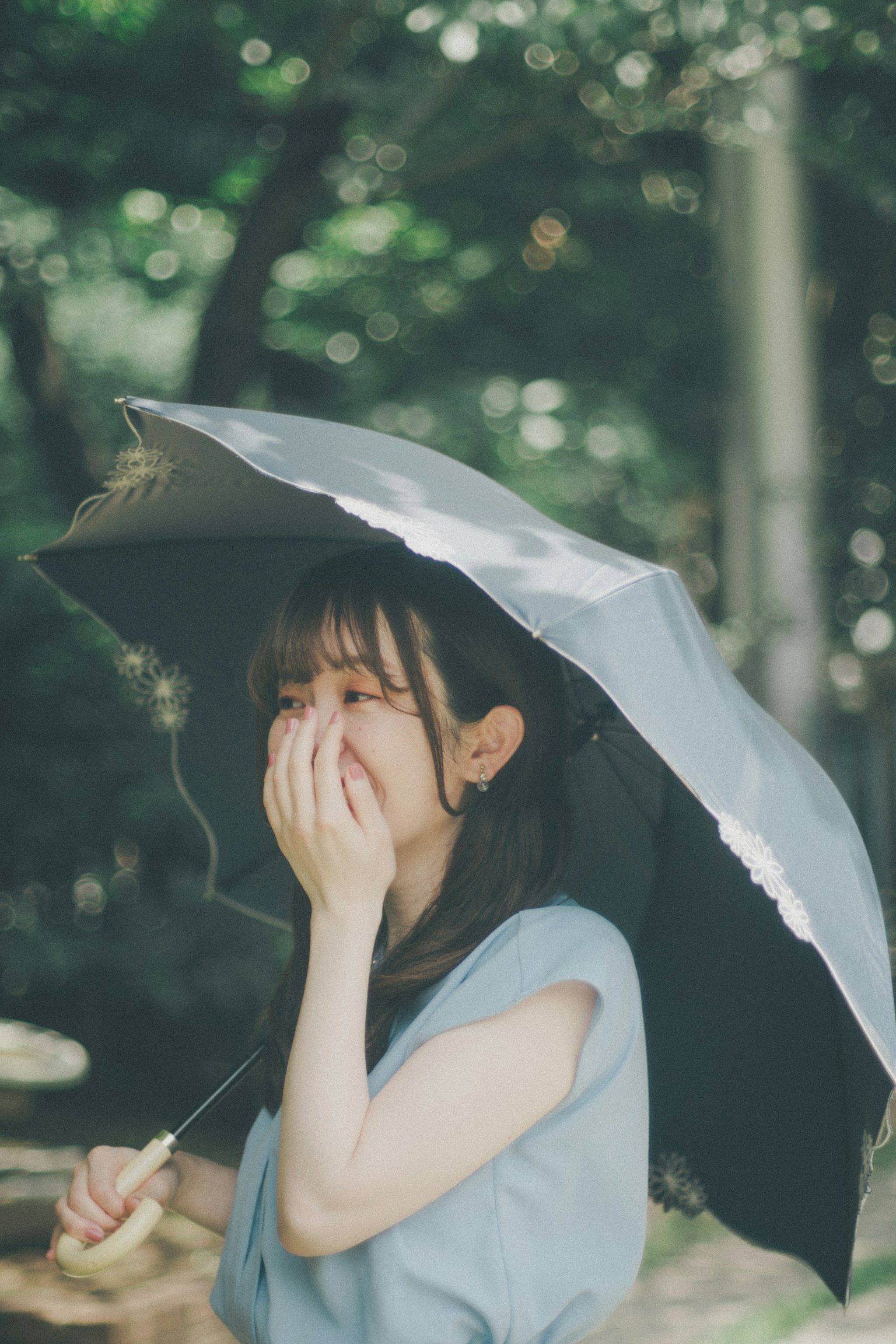 一位女性手持伞在微笑，背景为绿色