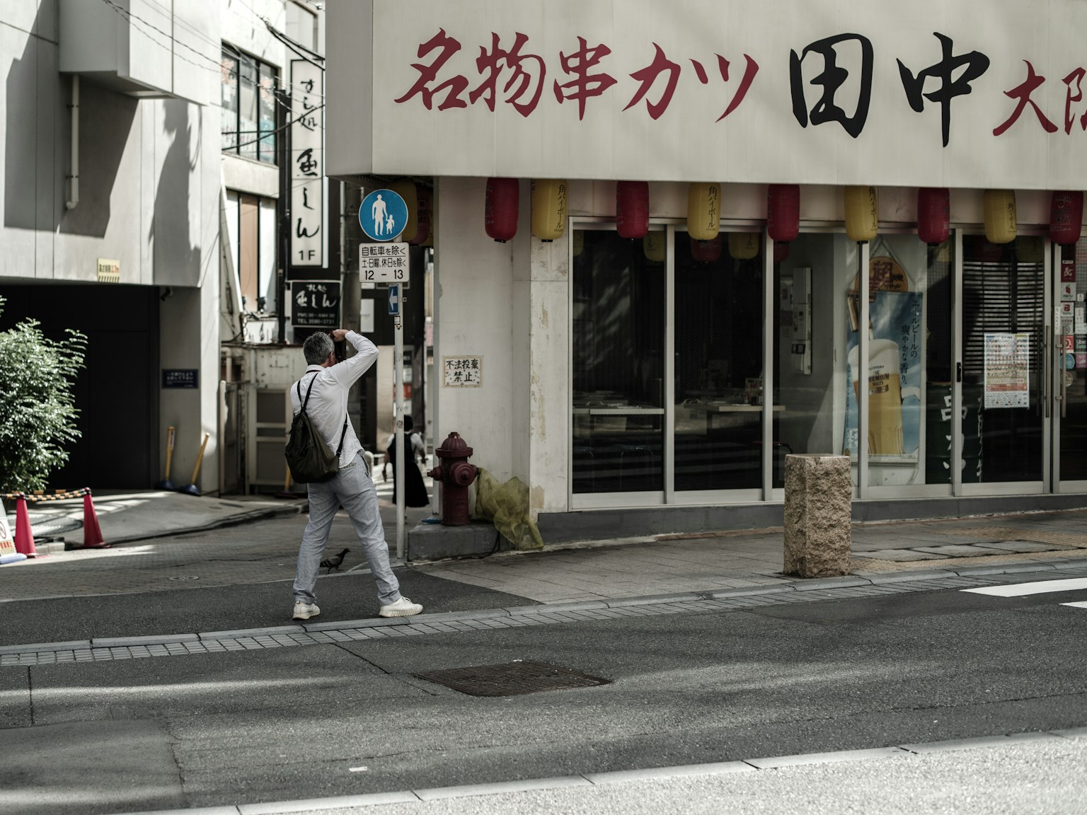 카메라를 들고 있는 남성 일본식 레스토랑 외관 앞