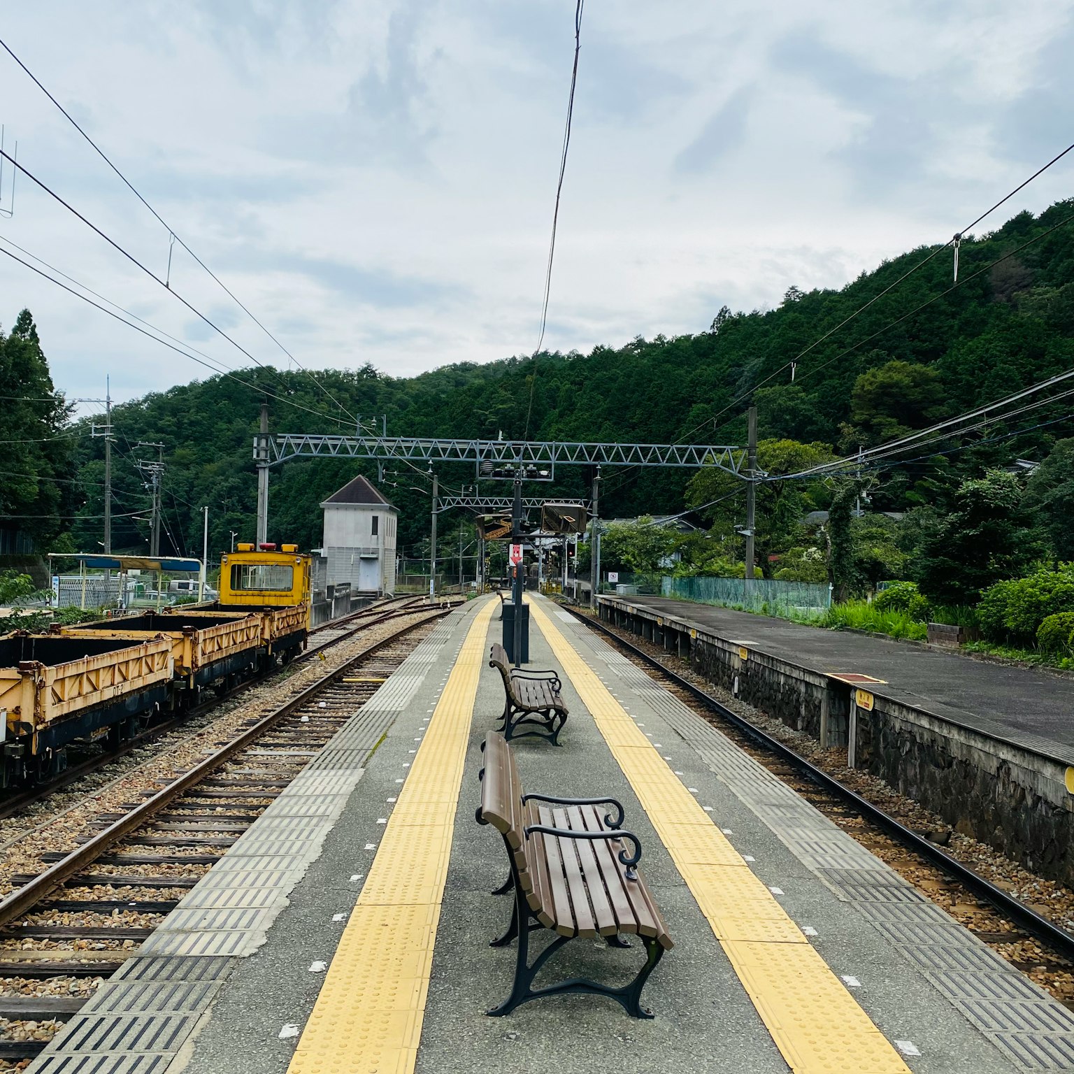 安靜的火車站台，長椅和山的背景